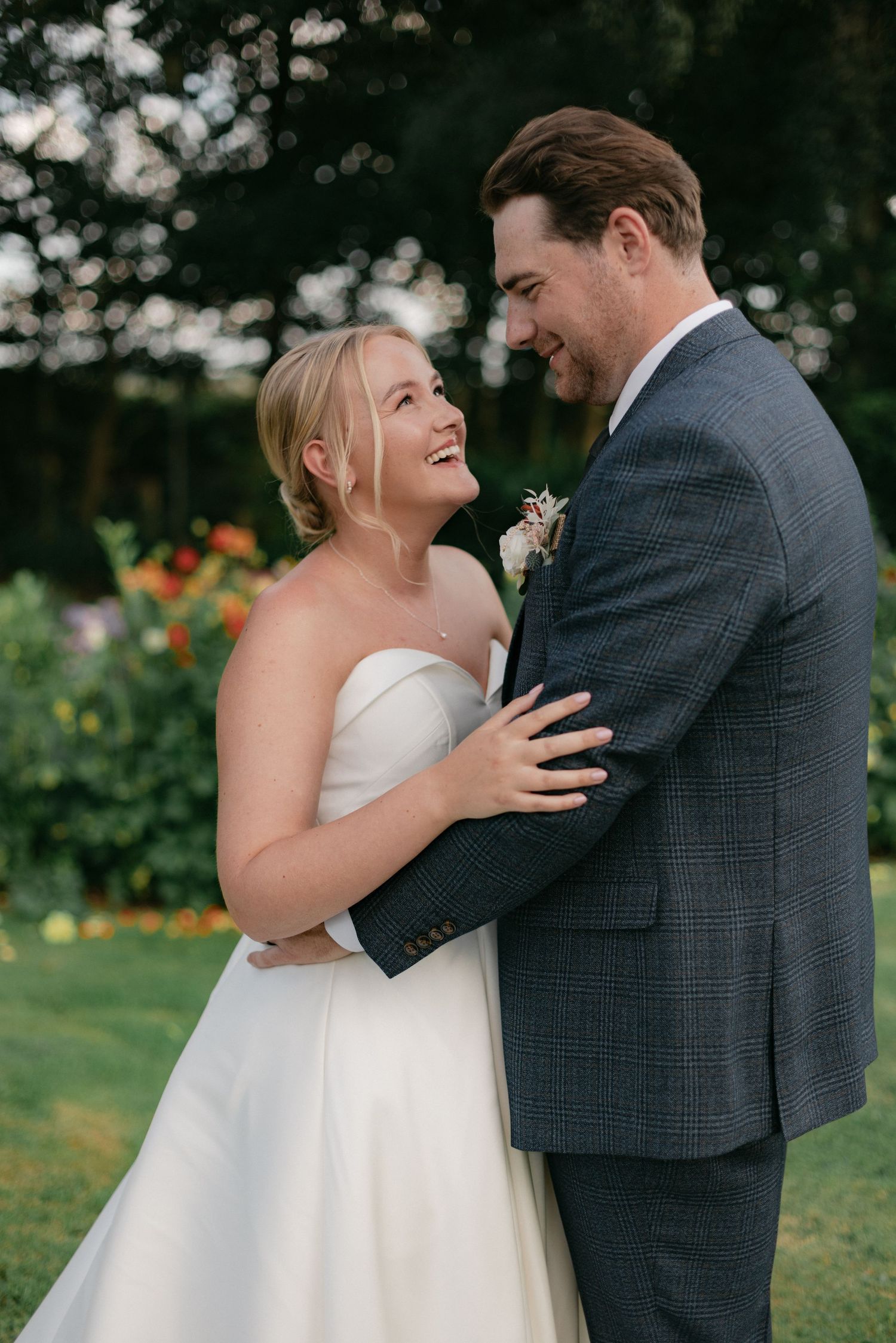 Candid moments between newlyweds sharing laughter in a garden setting.