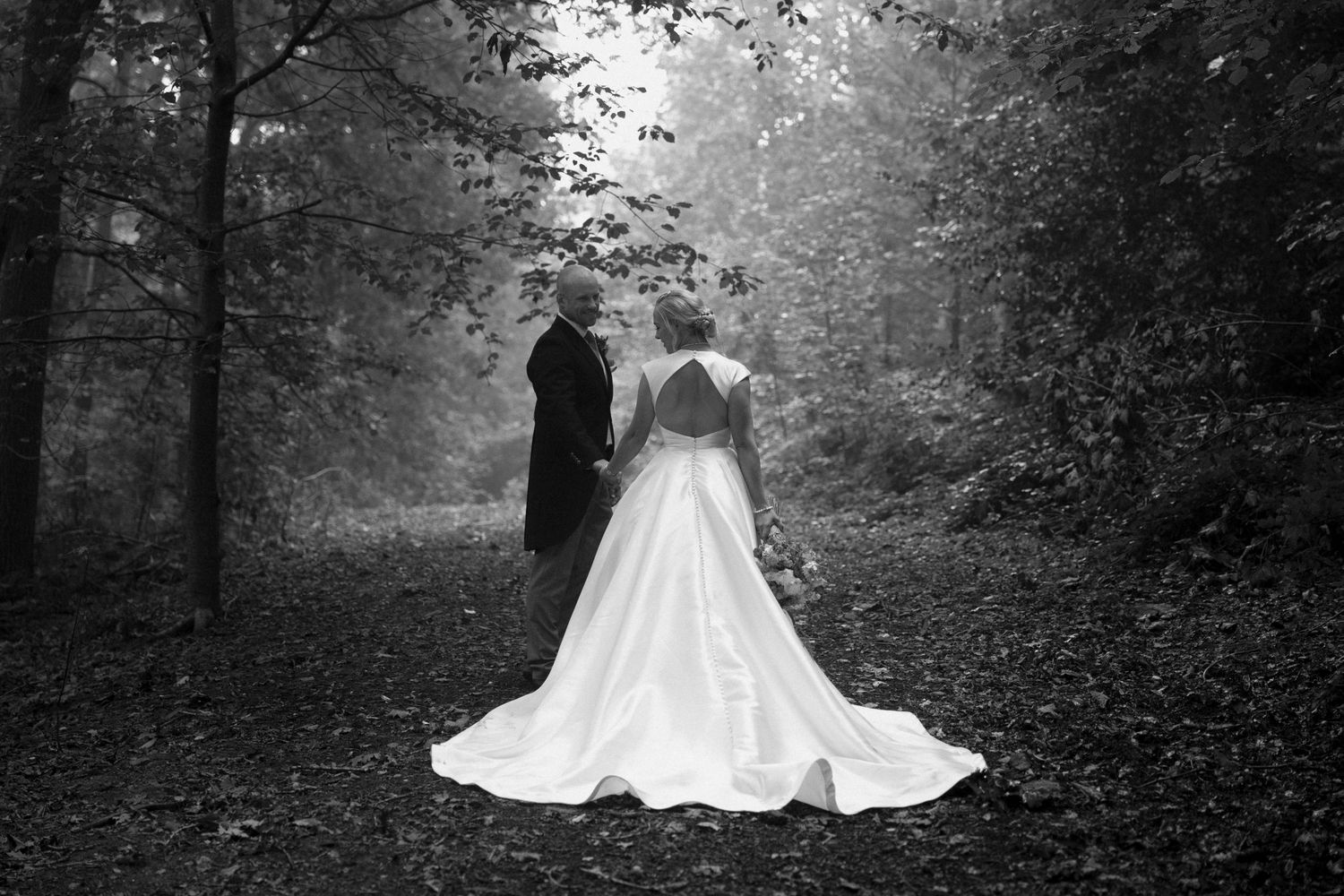 Elegant white wedding dress flowing in a misty forest setting.