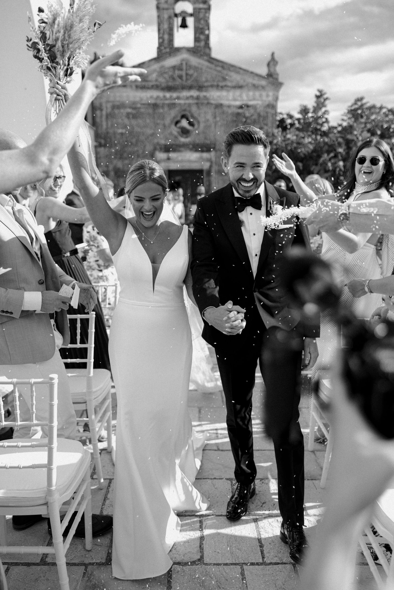 Black and white wedding photos showing celebratory moments outside a historic church.