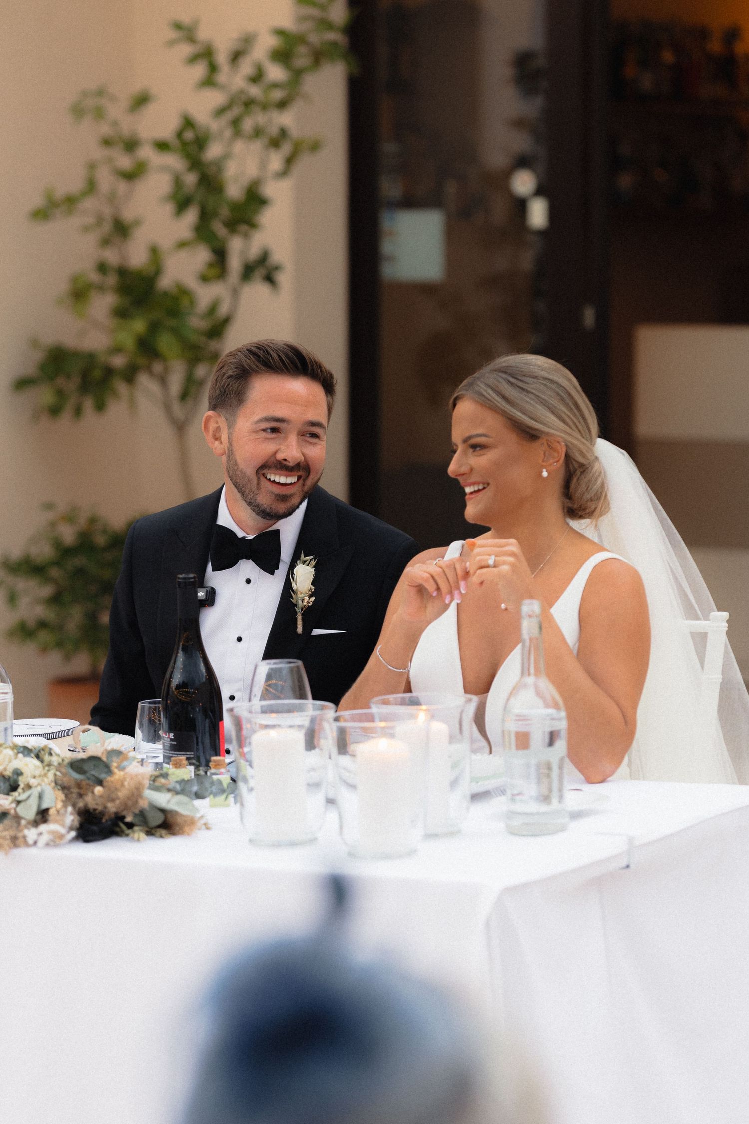 Newlyweds share an intimate moment at their reception head table.