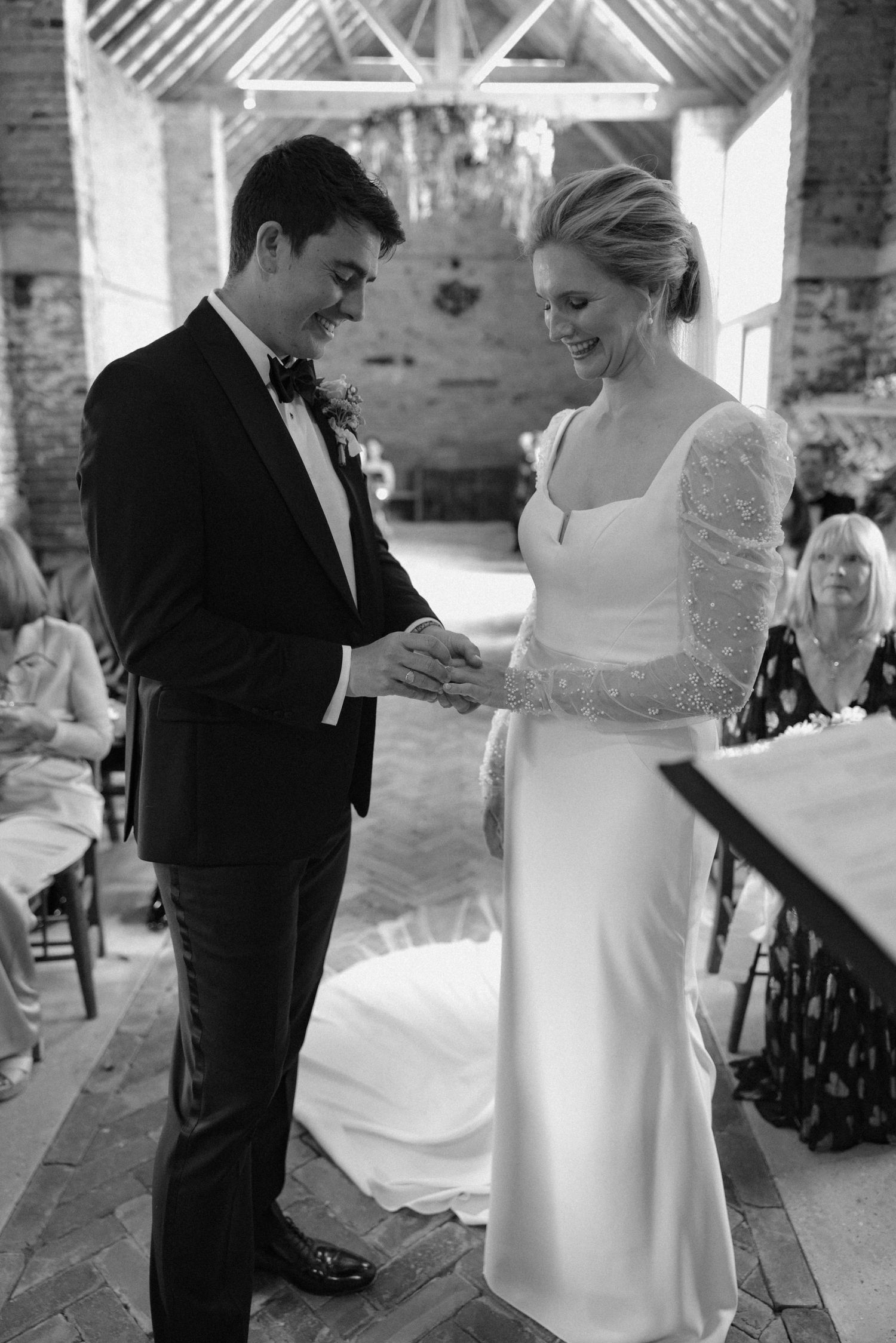Wedding couple interacting in a rustic brick venue with natural lighting.