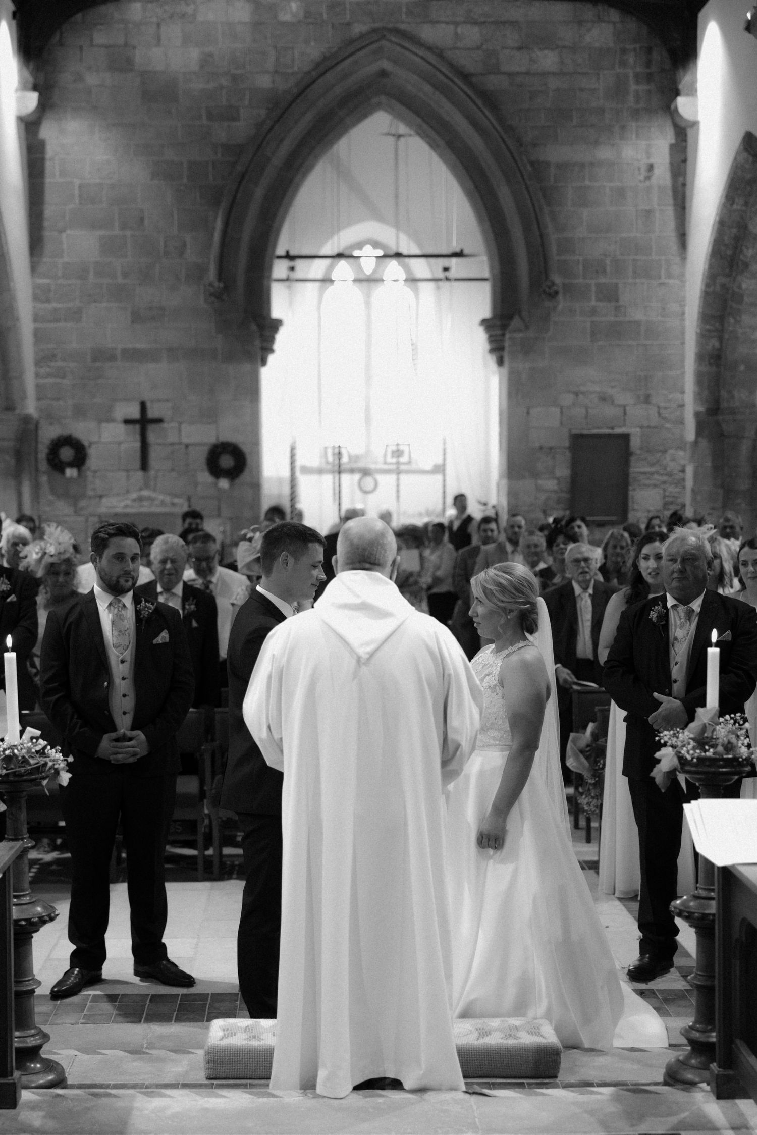 A traditional church wedding ceremony takes place in a grand stone cathedral.
