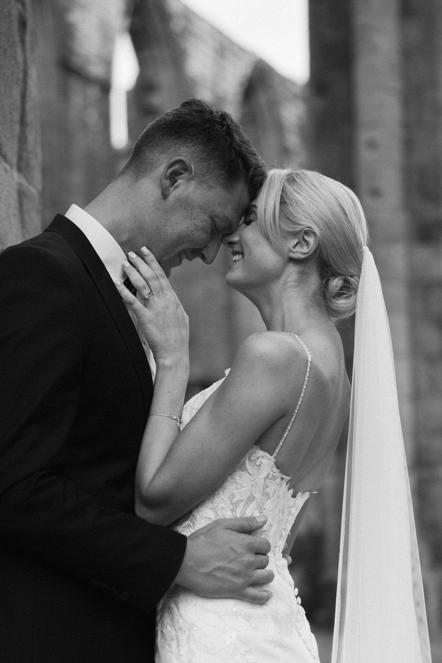 Artistic black and white wedding portraits showing tender moments between newlyweds.