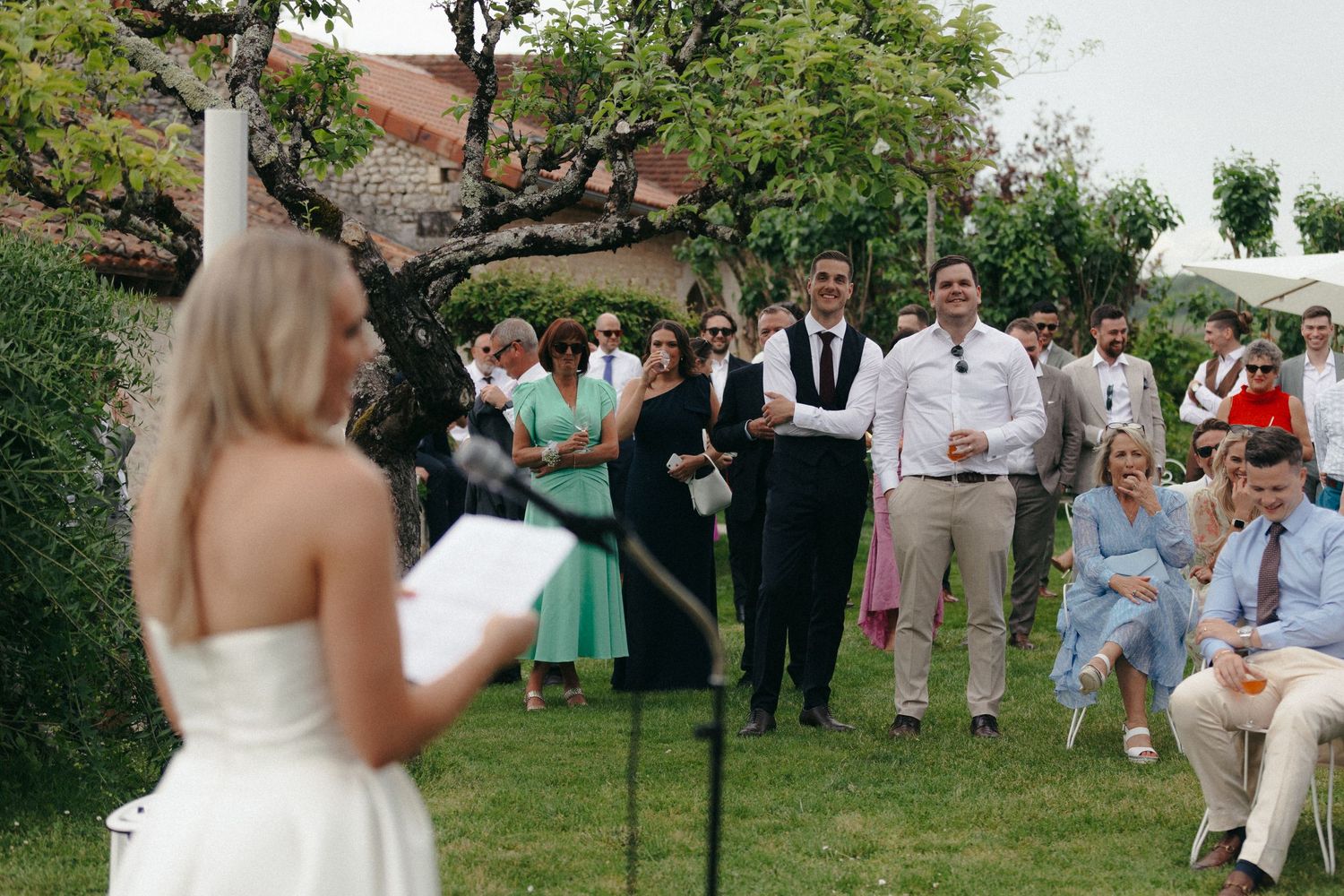 Wedding guests mingling on a lawn during an outdoor reception.