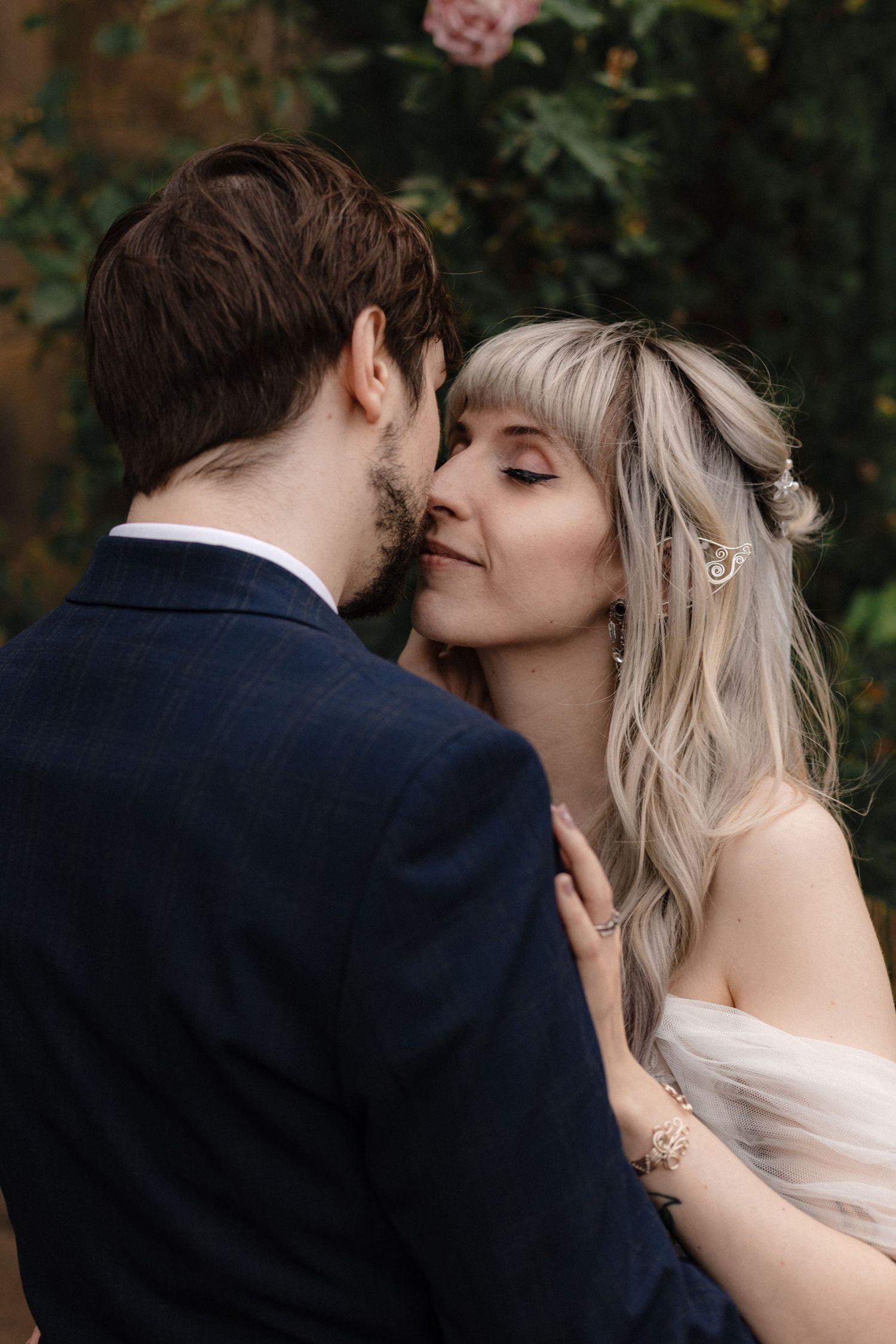 A romantic wedding moment captured in an intimate series of close-up shots among garden foliage.