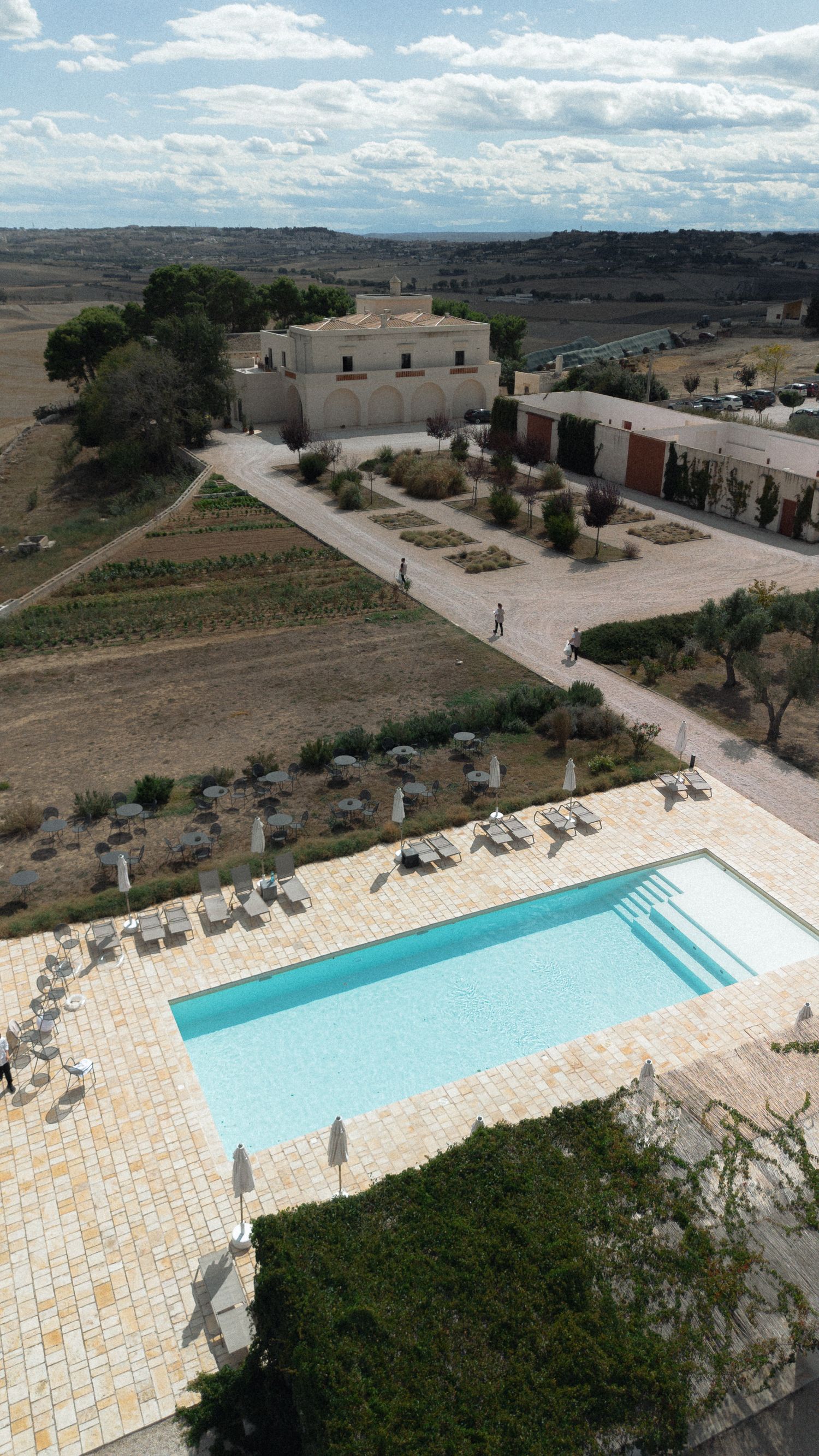 Aerial view of a luxury villa with swimming pool surrounded by arid landscape.