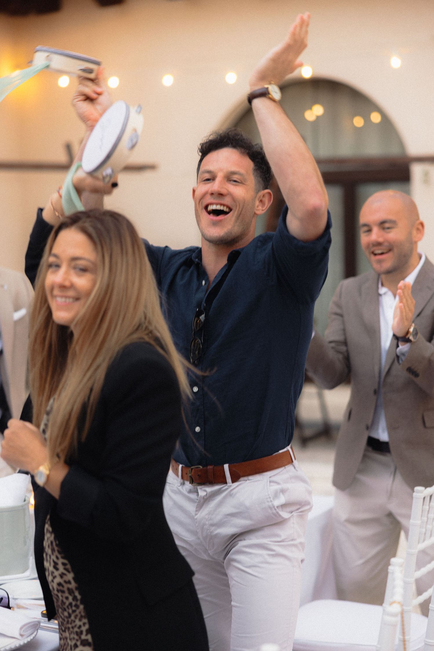 Guests at a wedding reception wave napkins and celebrate with enthusiasm.