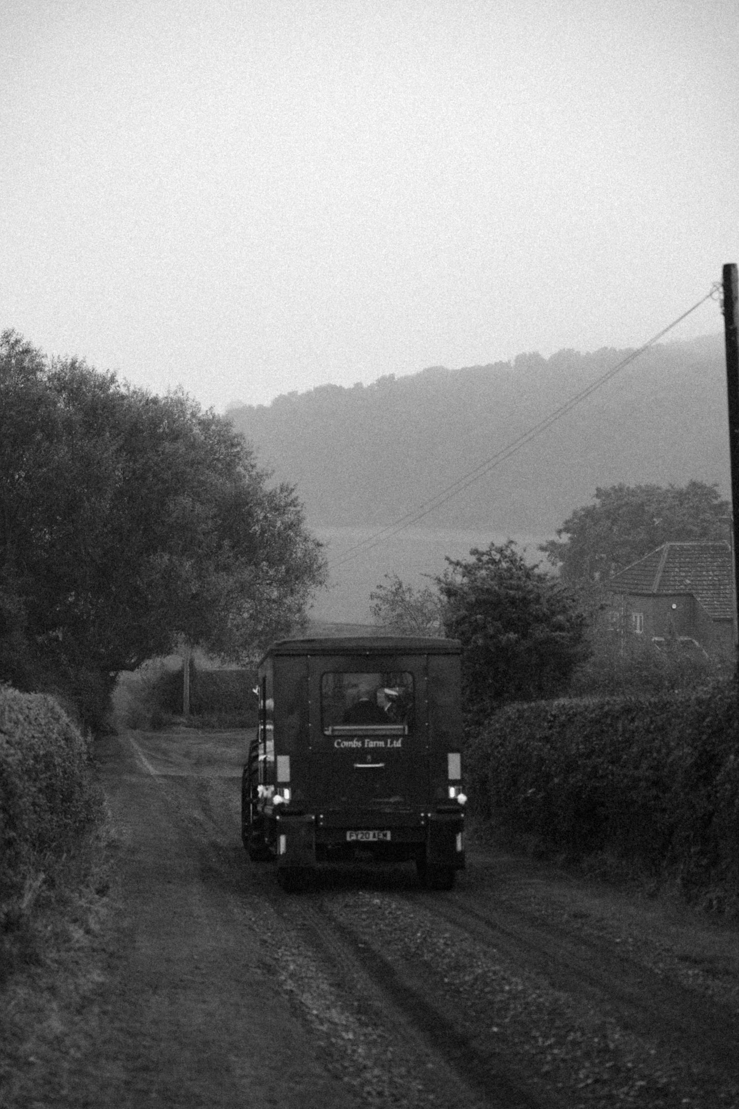 Vintage black and white photograph of a railway car on a misty rural track.