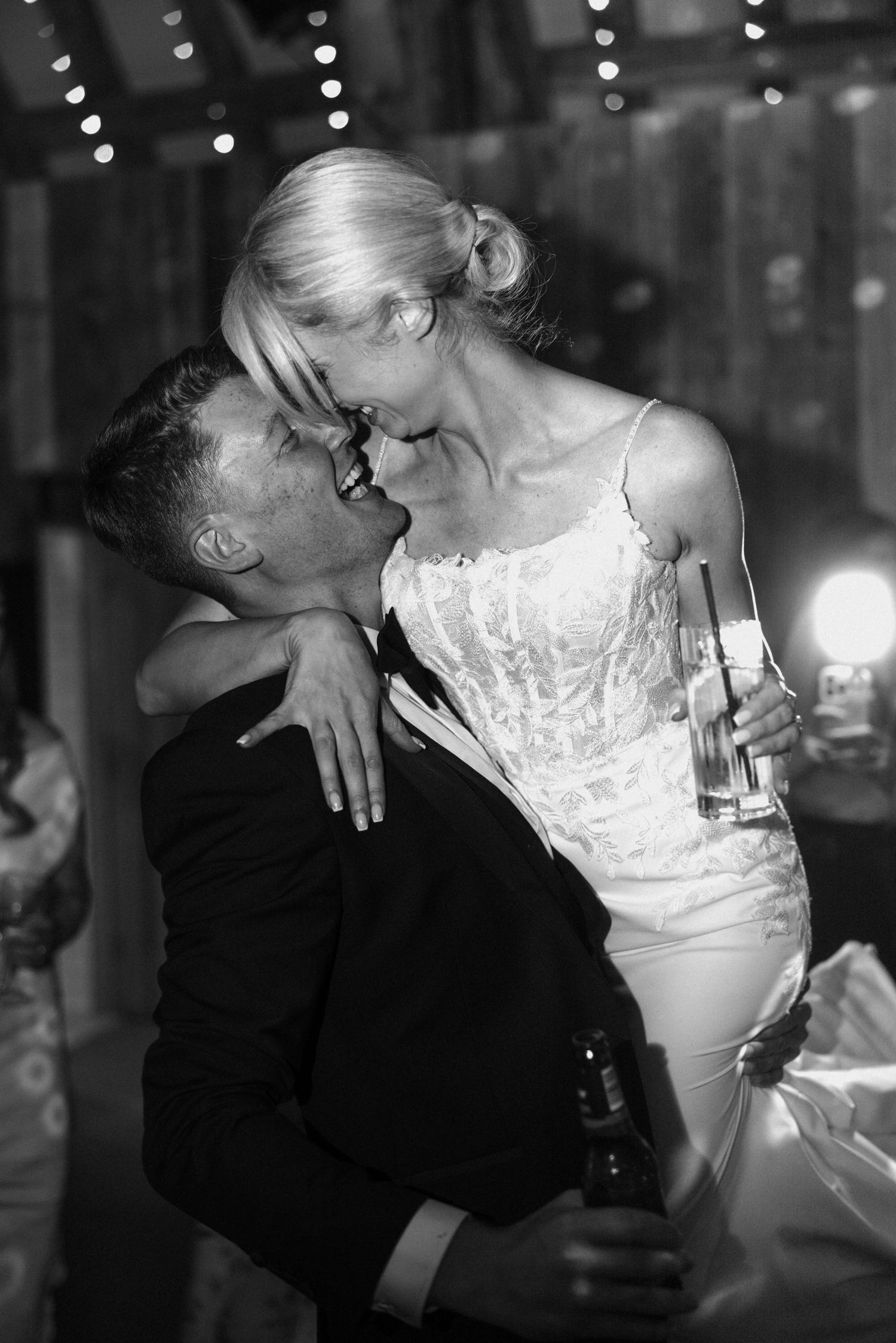 An intimate black and white photo of a couple embracing during their wedding celebration.