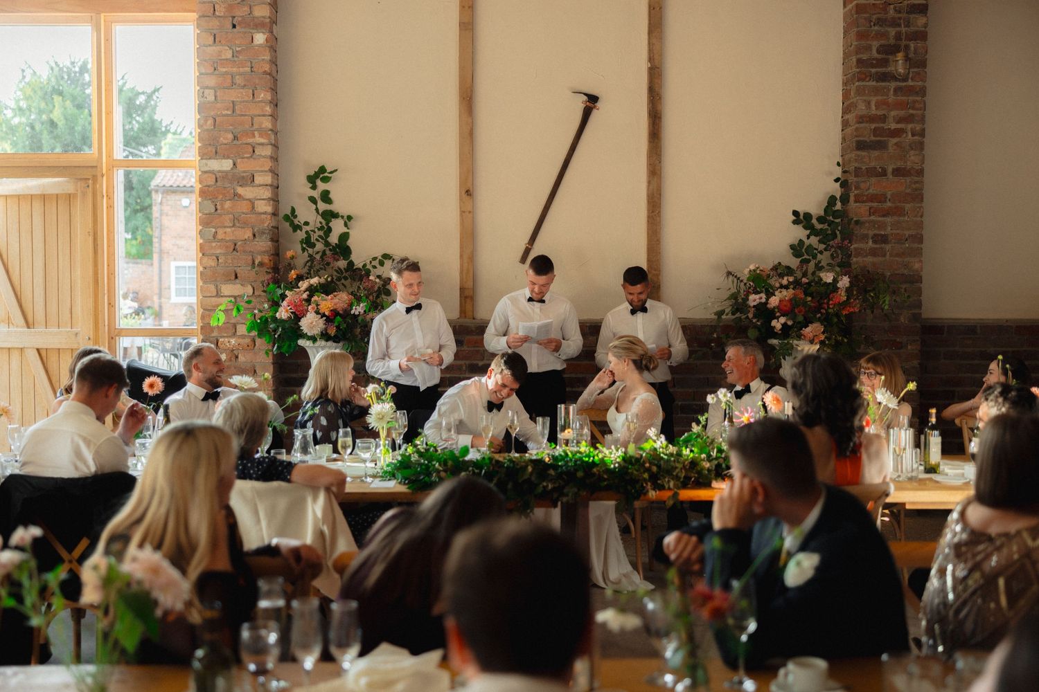 Wedding reception in a bright venue with brick walls and large windows.