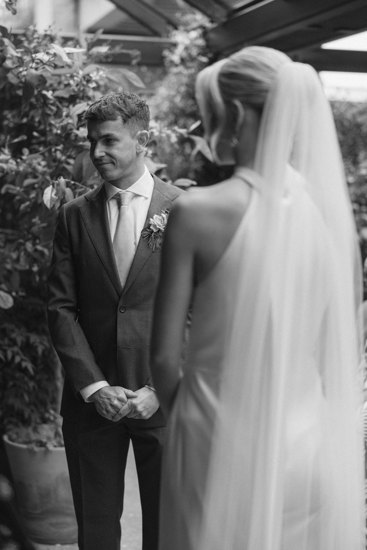 Intimate wedding ceremony moment in a greenhouse setting.