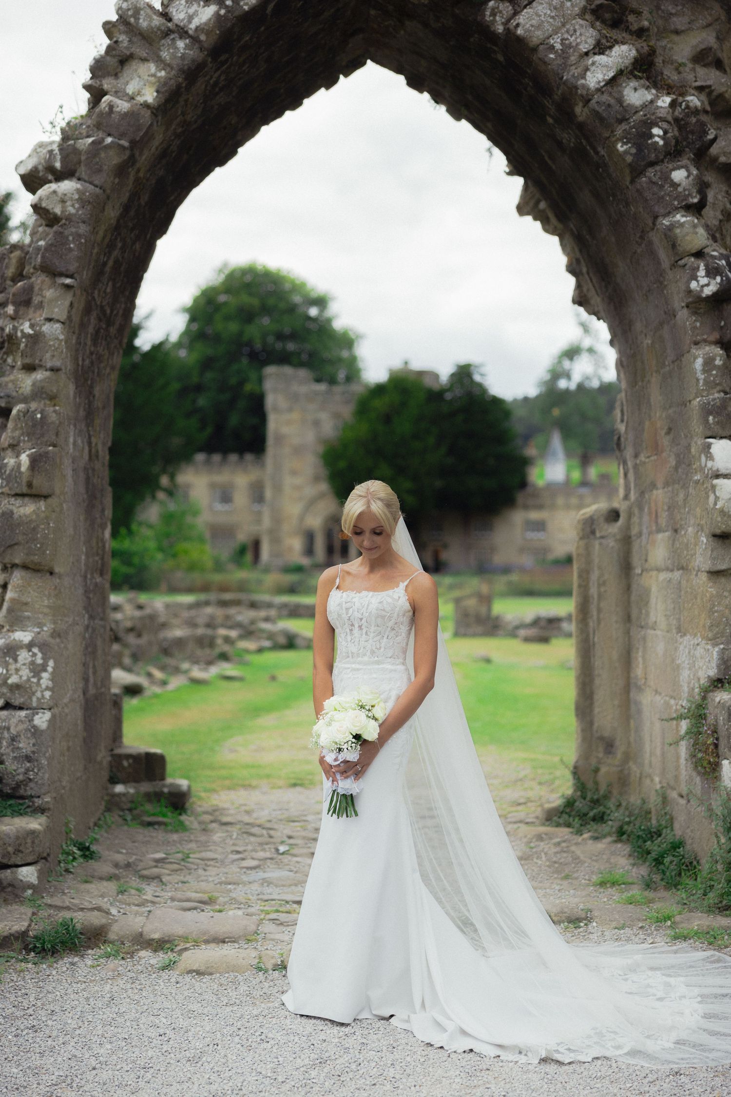 A wedding dress photoshoot under stone archways at an ancient ruins site.