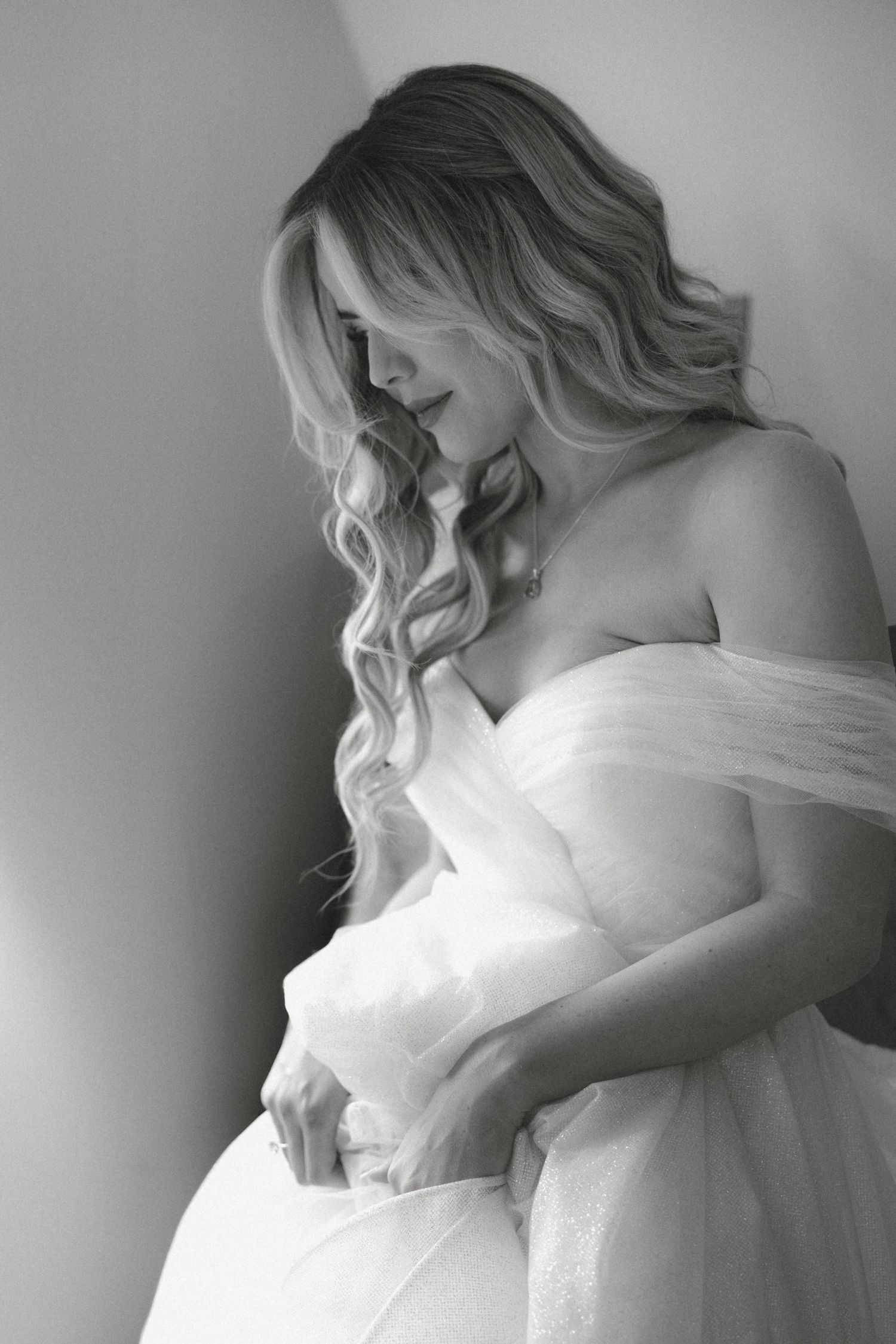 Ethereal black and white bridal portrait with flowing veil and soft lighting.