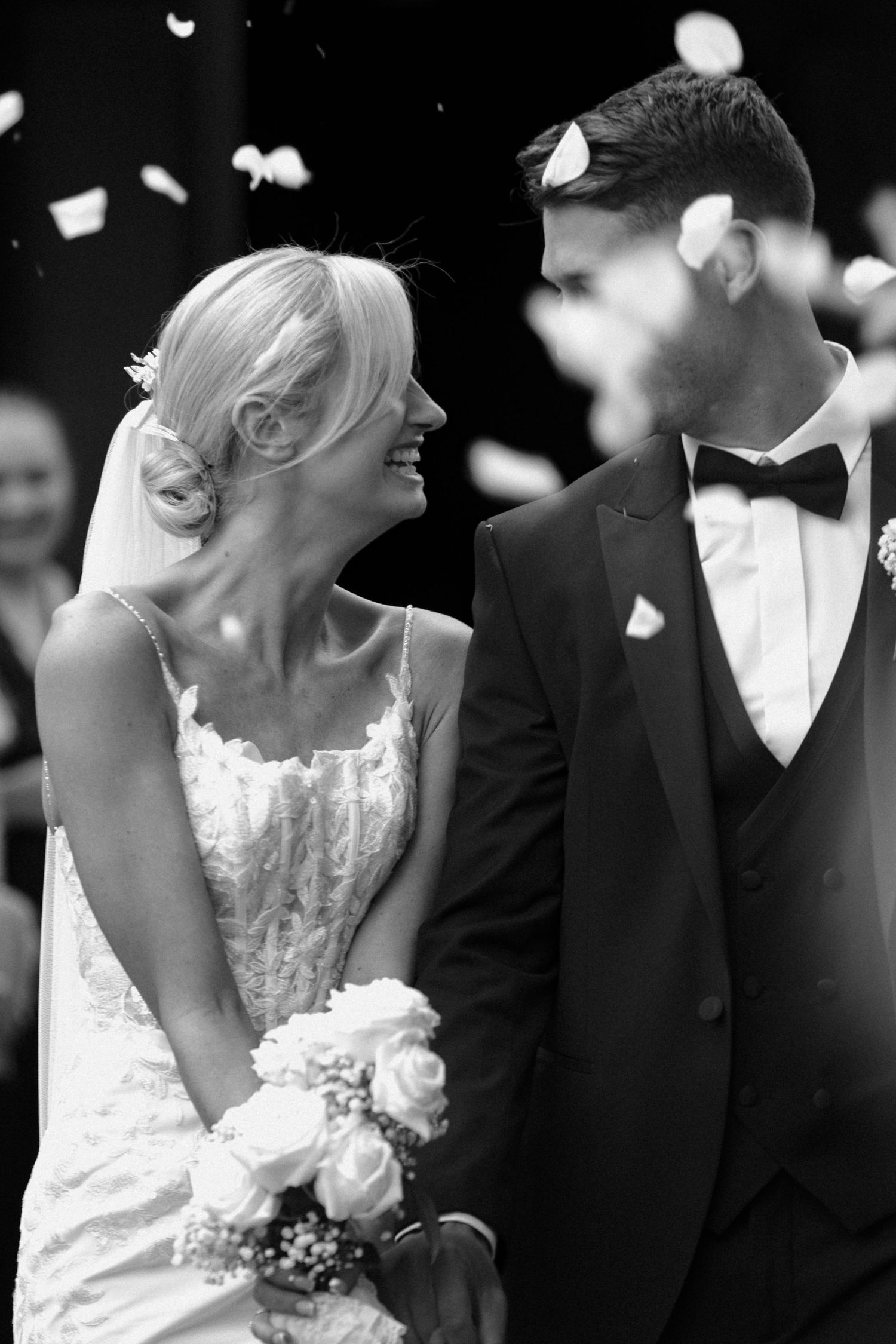 Black and white wedding photo sequence showing couple kissing while confetti falls around them.