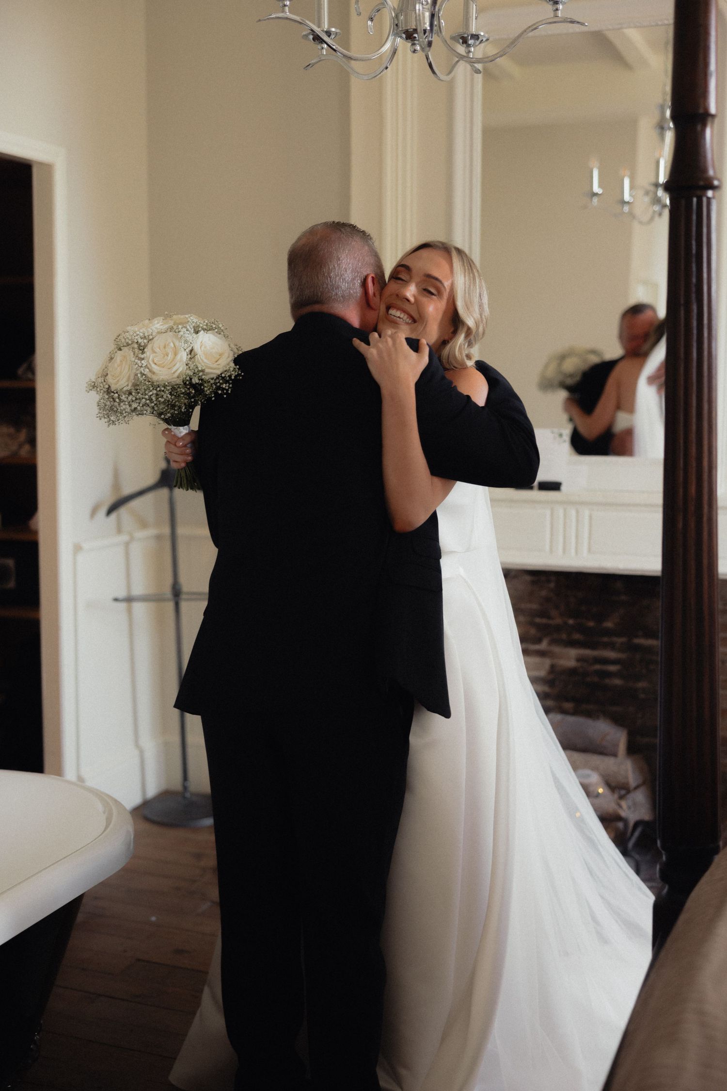 Emotional first look moment between father and bride in an elegant room.