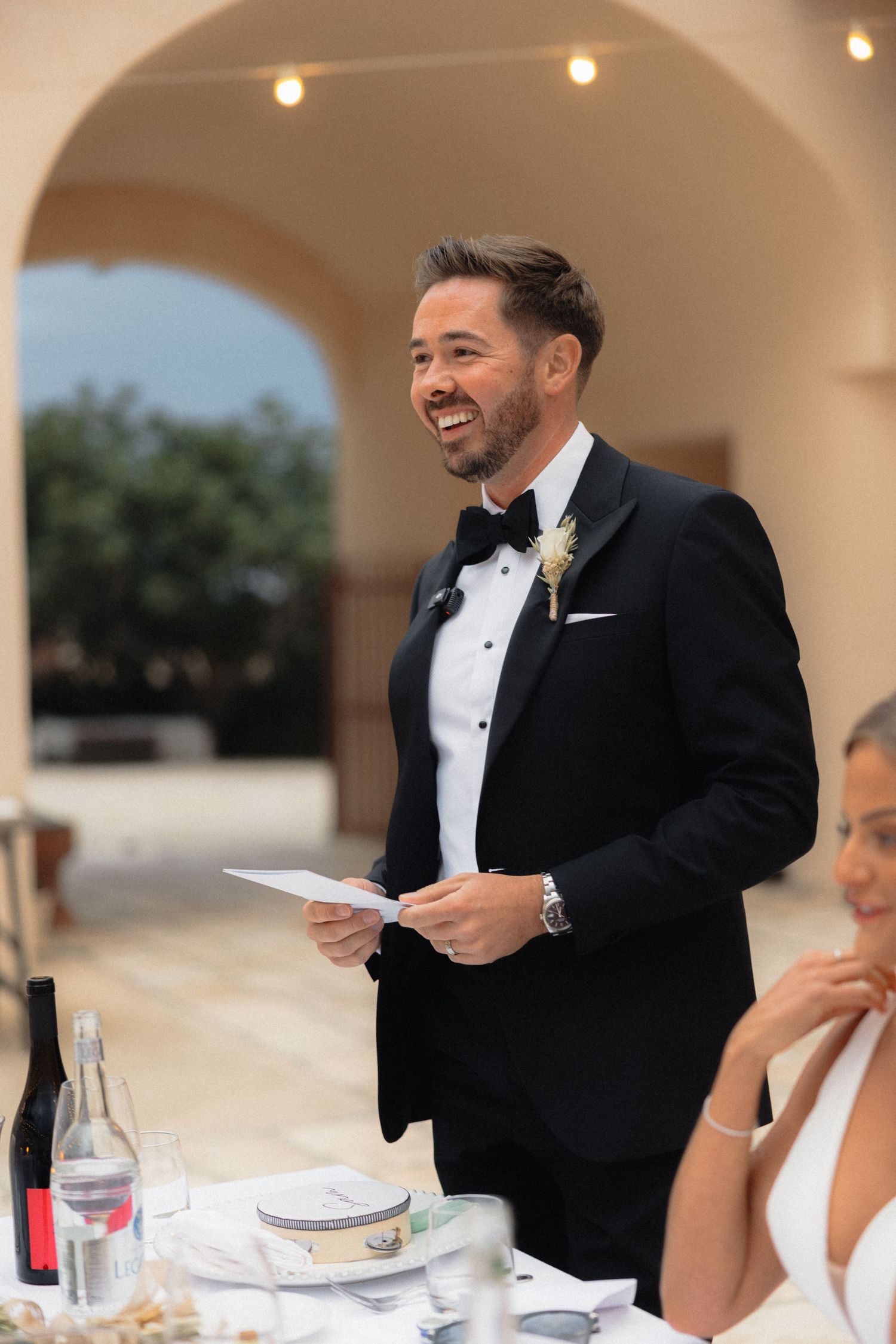 Wedding reception speech moment captured under elegant archways.