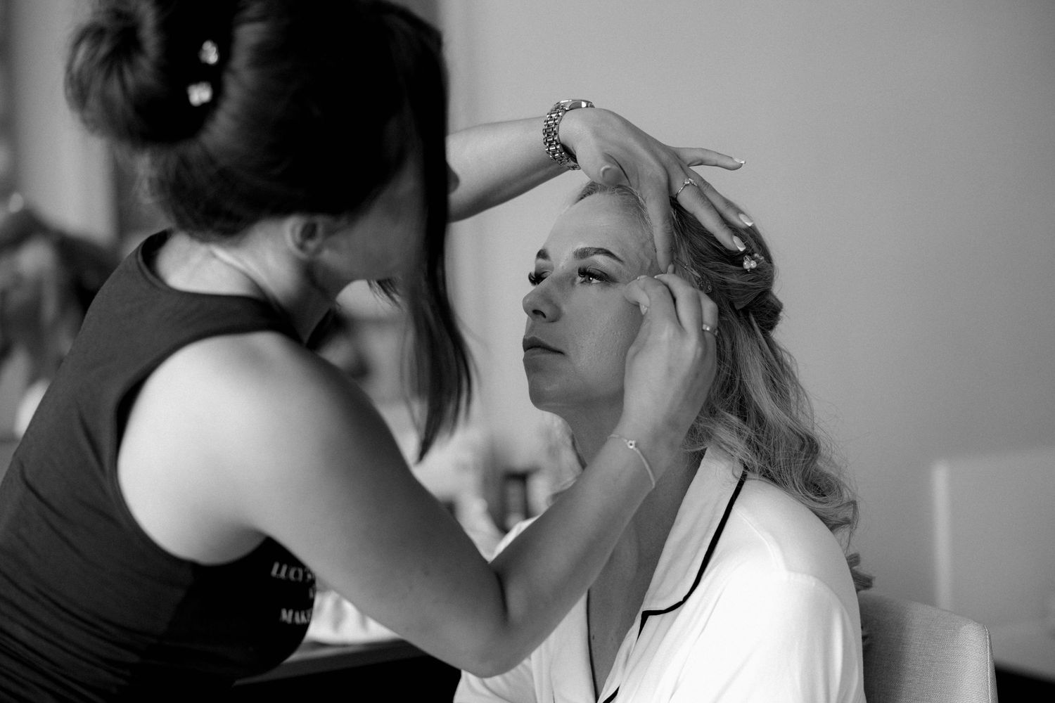 Makeup artist applying cosmetics during bridal preparation.