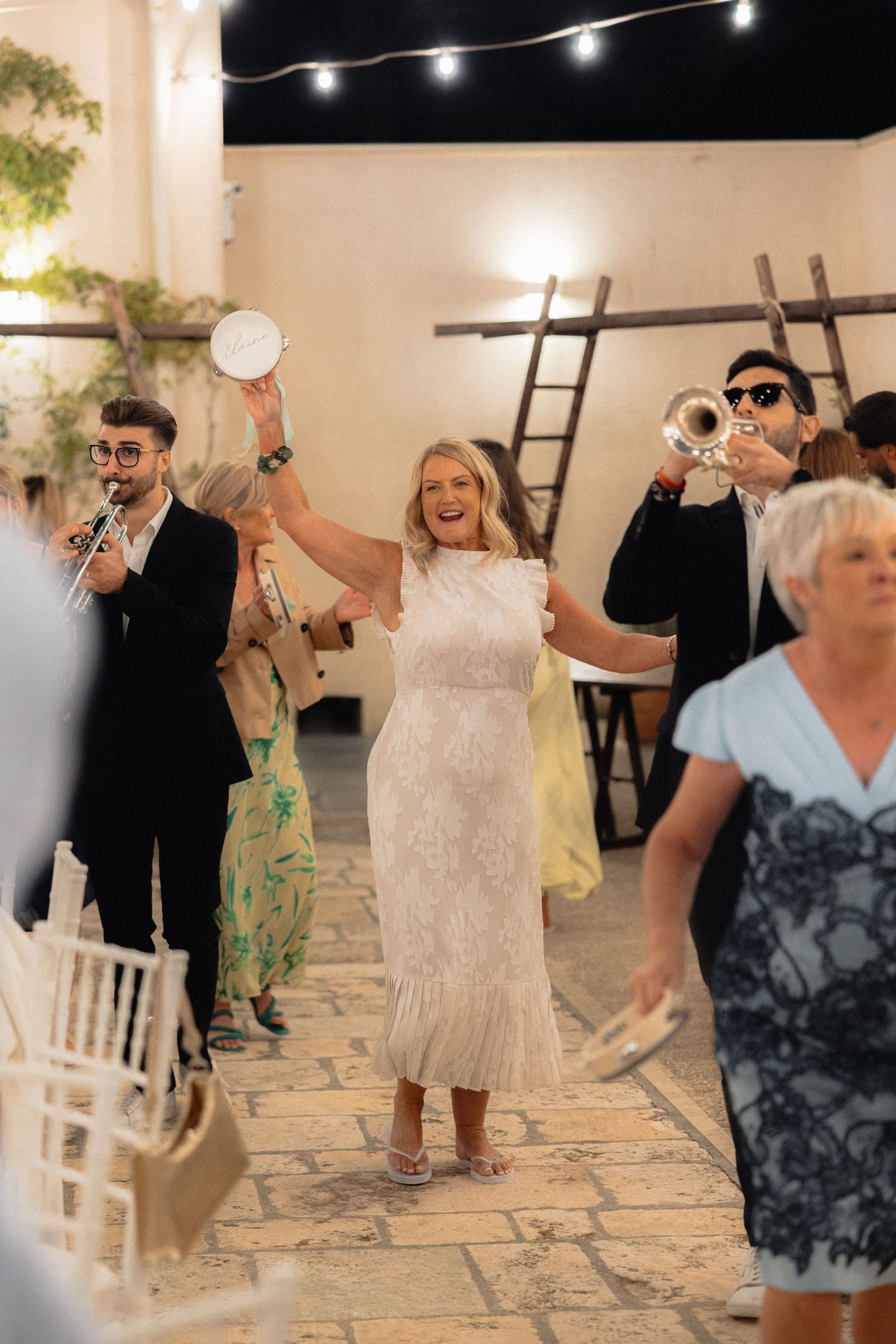 Wedding celebration with guests dancing and having fun on a stone patio.