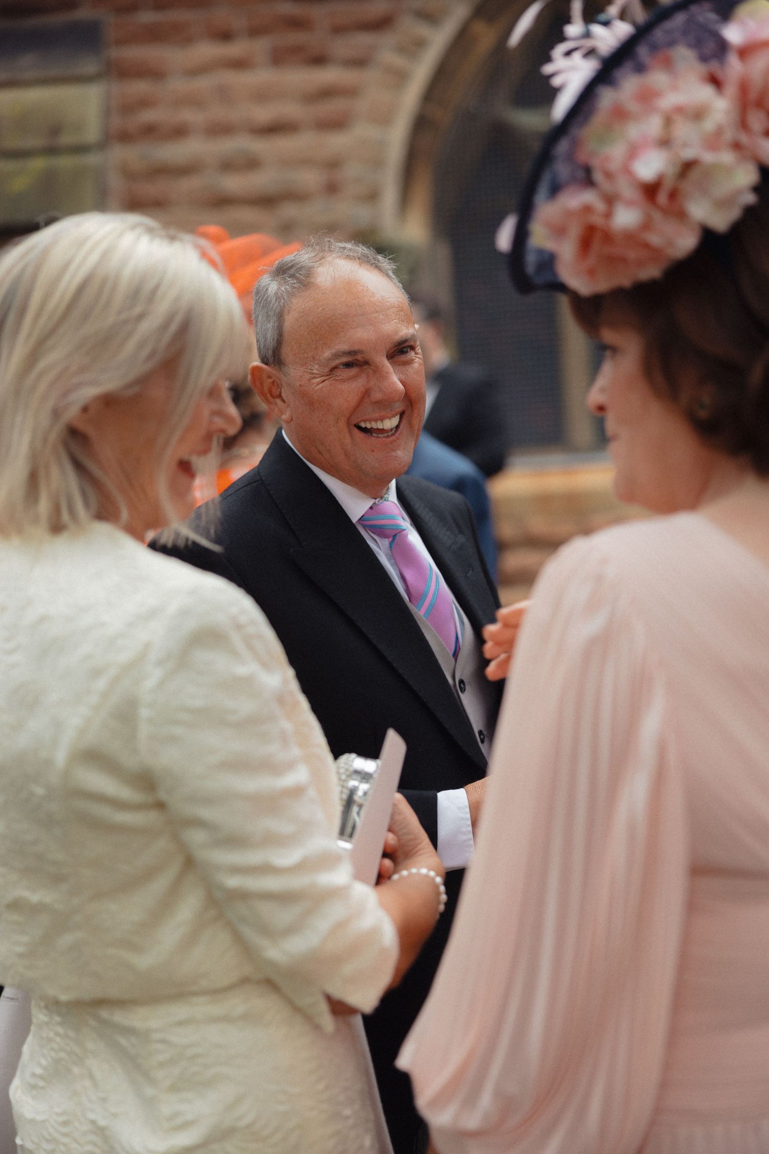 Wedding guests engaged in cheerful conversation during reception.