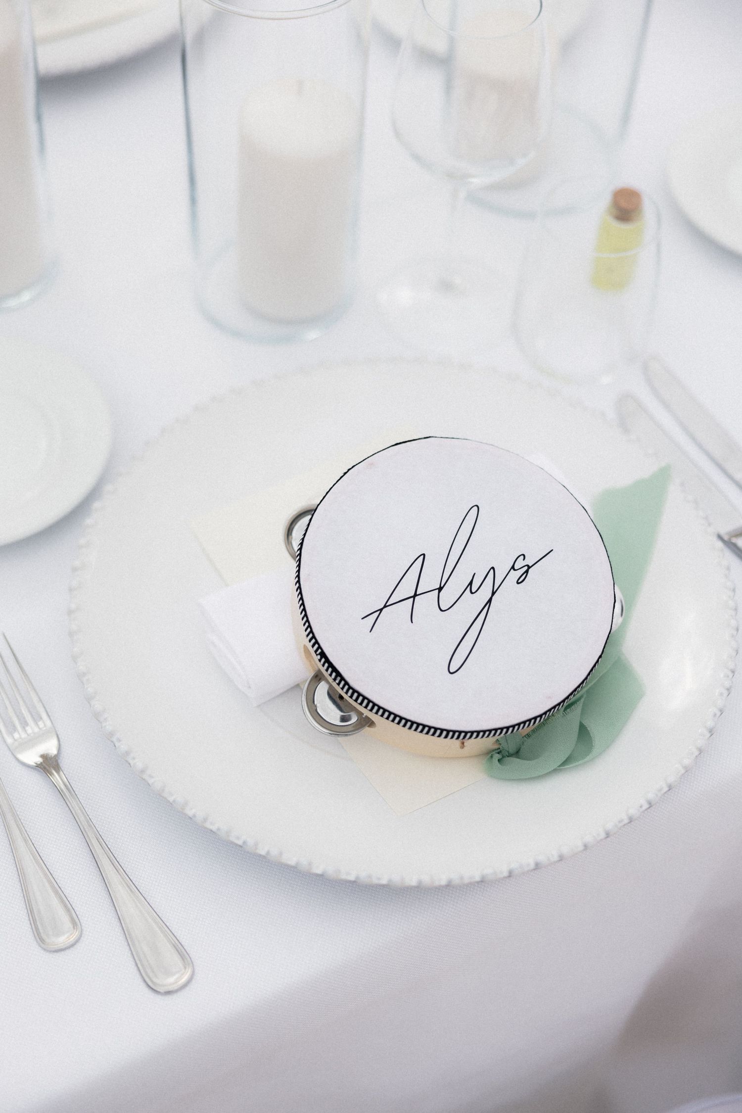 White place setting with calligraphy name card at formal wedding dinner.