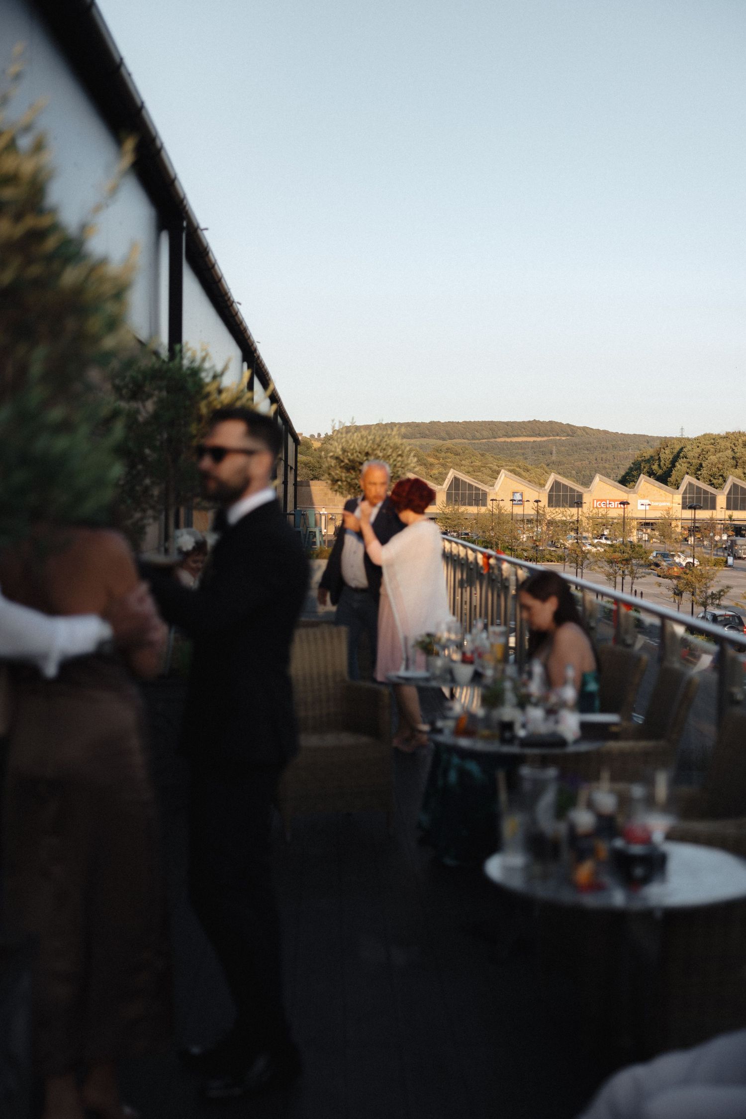 Wedding reception venue at sunset with guests mingling on an outdoor patio.