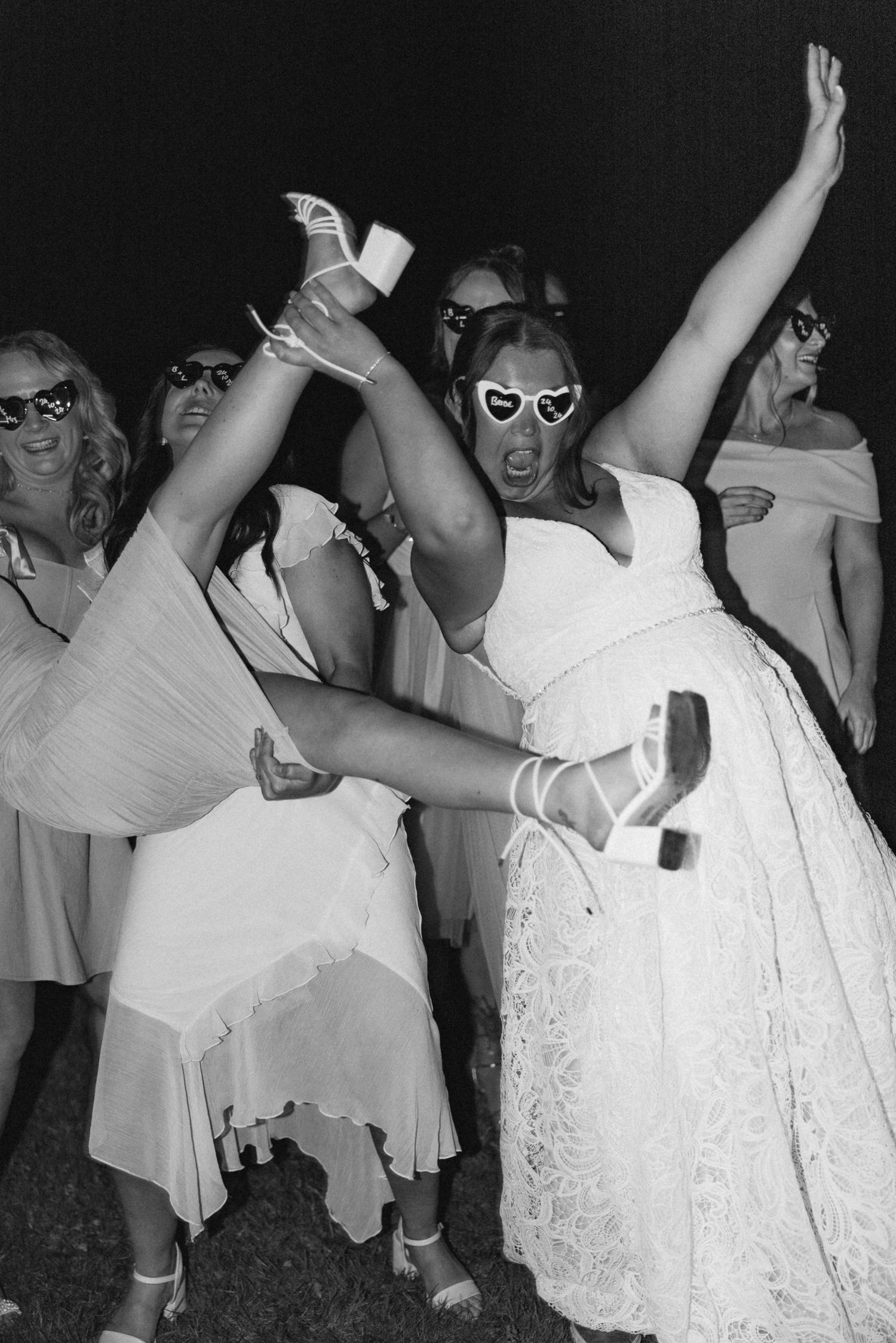 Energetic dance party with guests in white dresses and sunglasses.