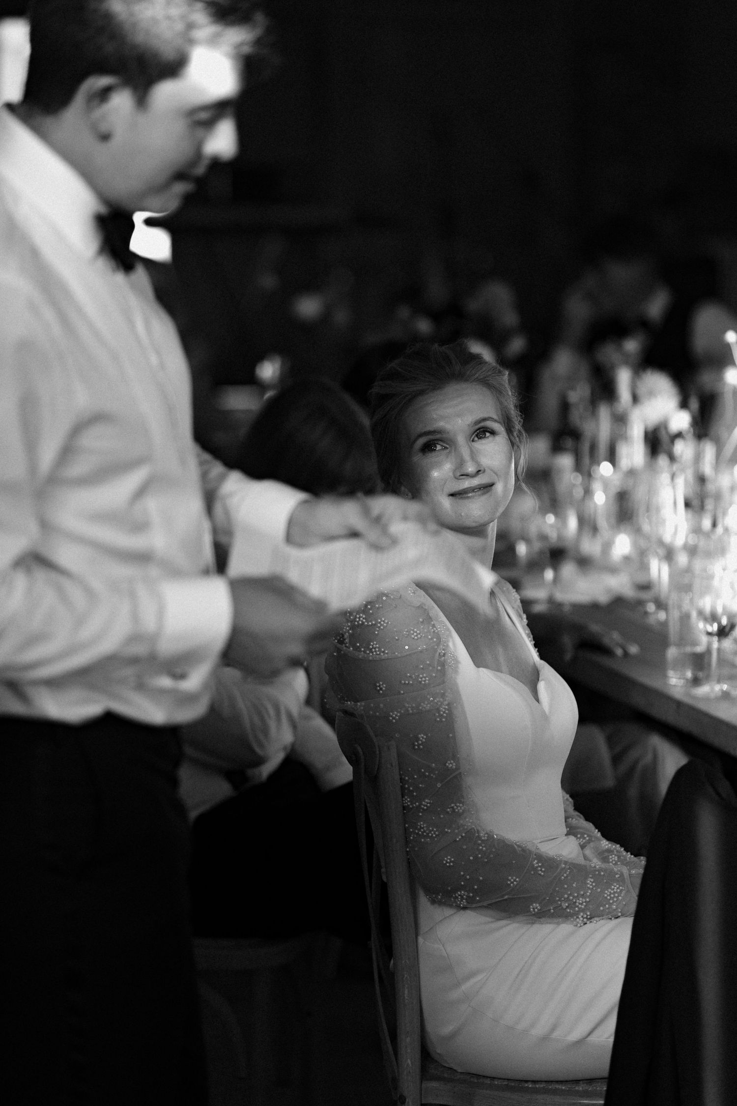 Black and white photo of guests being served at an elegant wedding reception.