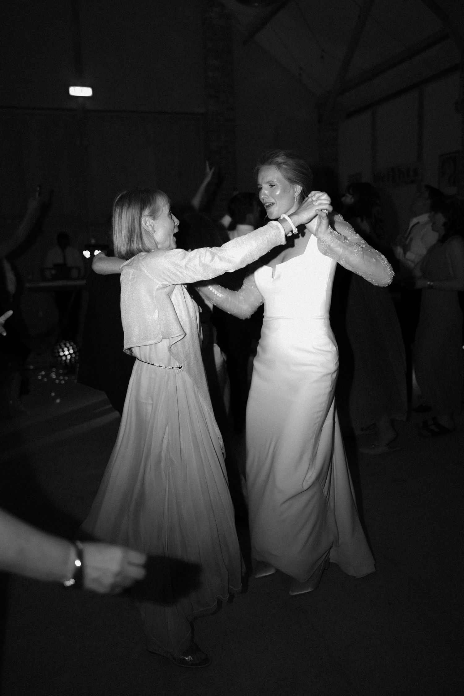 Dancers in formal attire moving energetically at an indoor event.