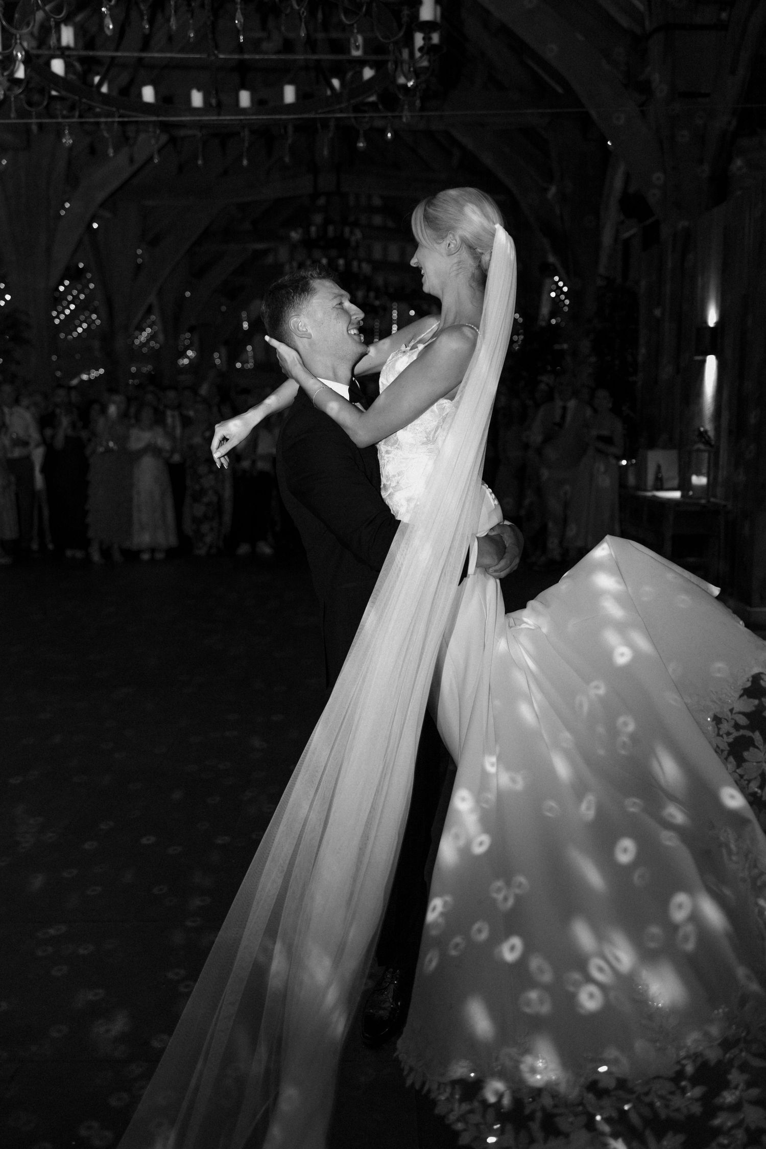A romantic black and white wedding photo shows a couple sharing an intimate dance with dramatic lighting and shadows.