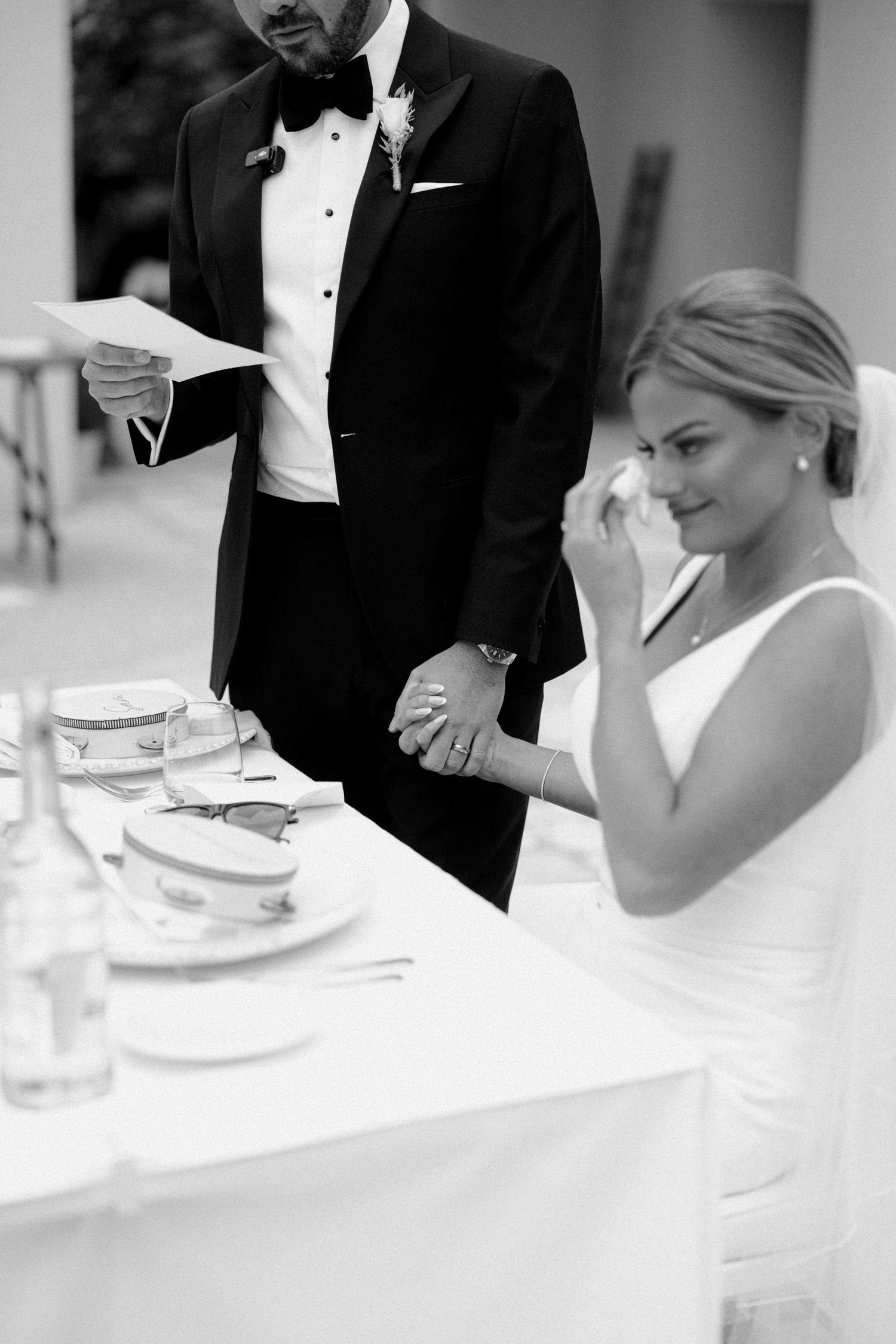 Black and white candid moment during wedding reception speeches.