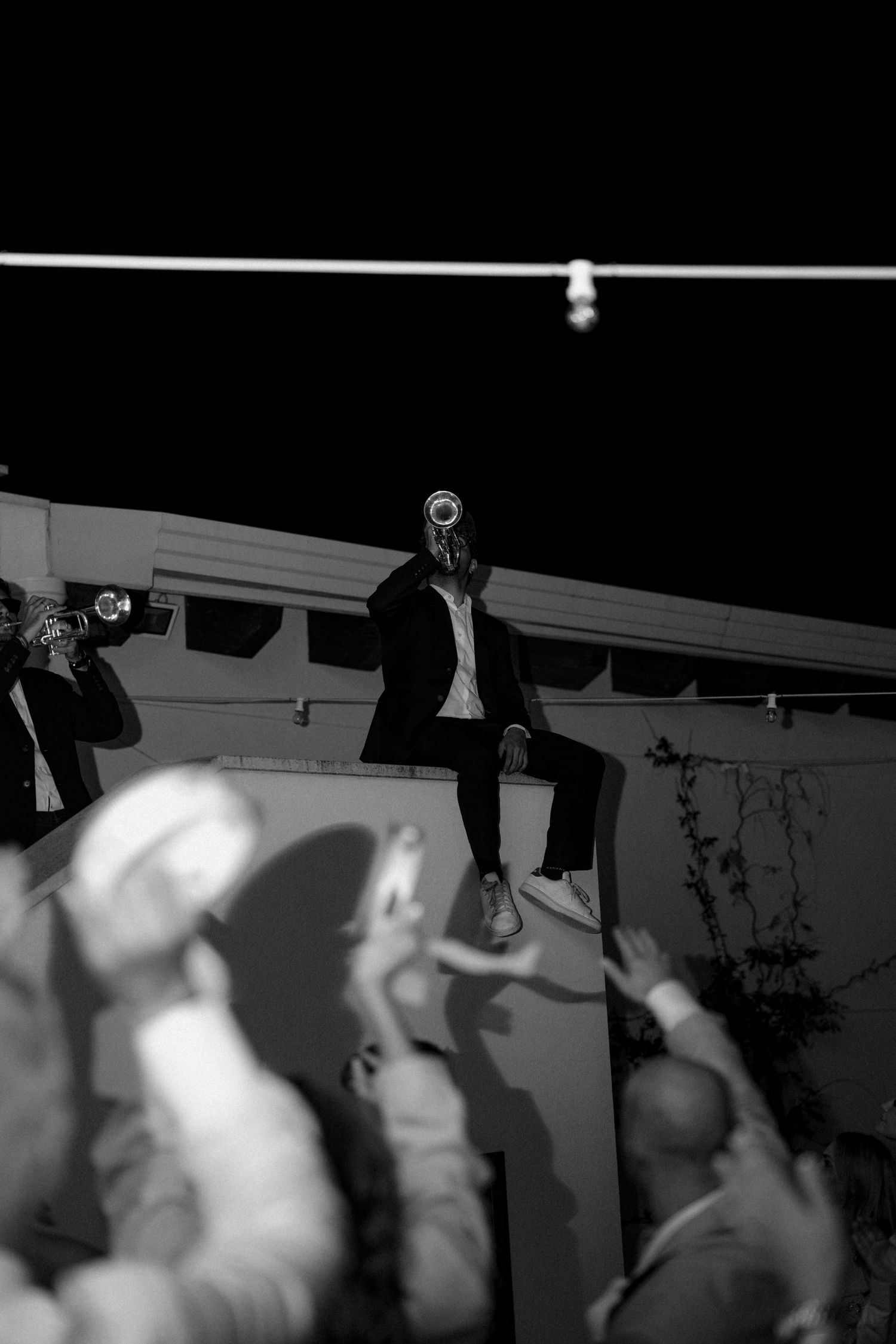 Silhouettes of people dancing and jumping at a nighttime party.