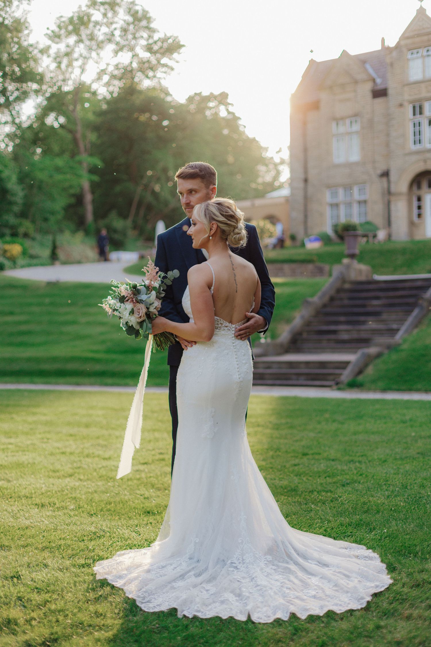 Elegant wedding portraits captured at golden hour on the grounds of a historic mansion.