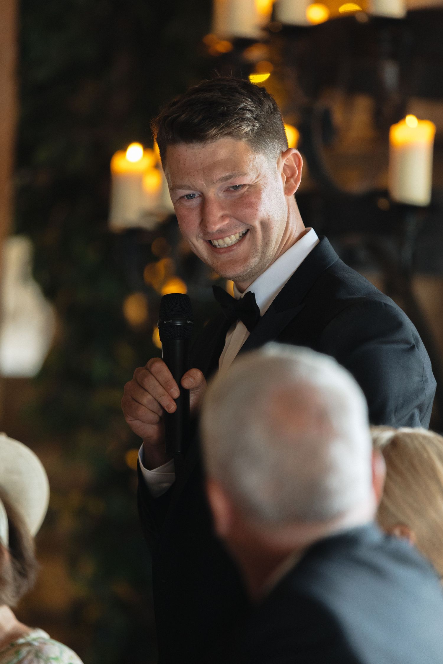 Candid reception moment captured in warm lighting with guests sharing joyful expressions.