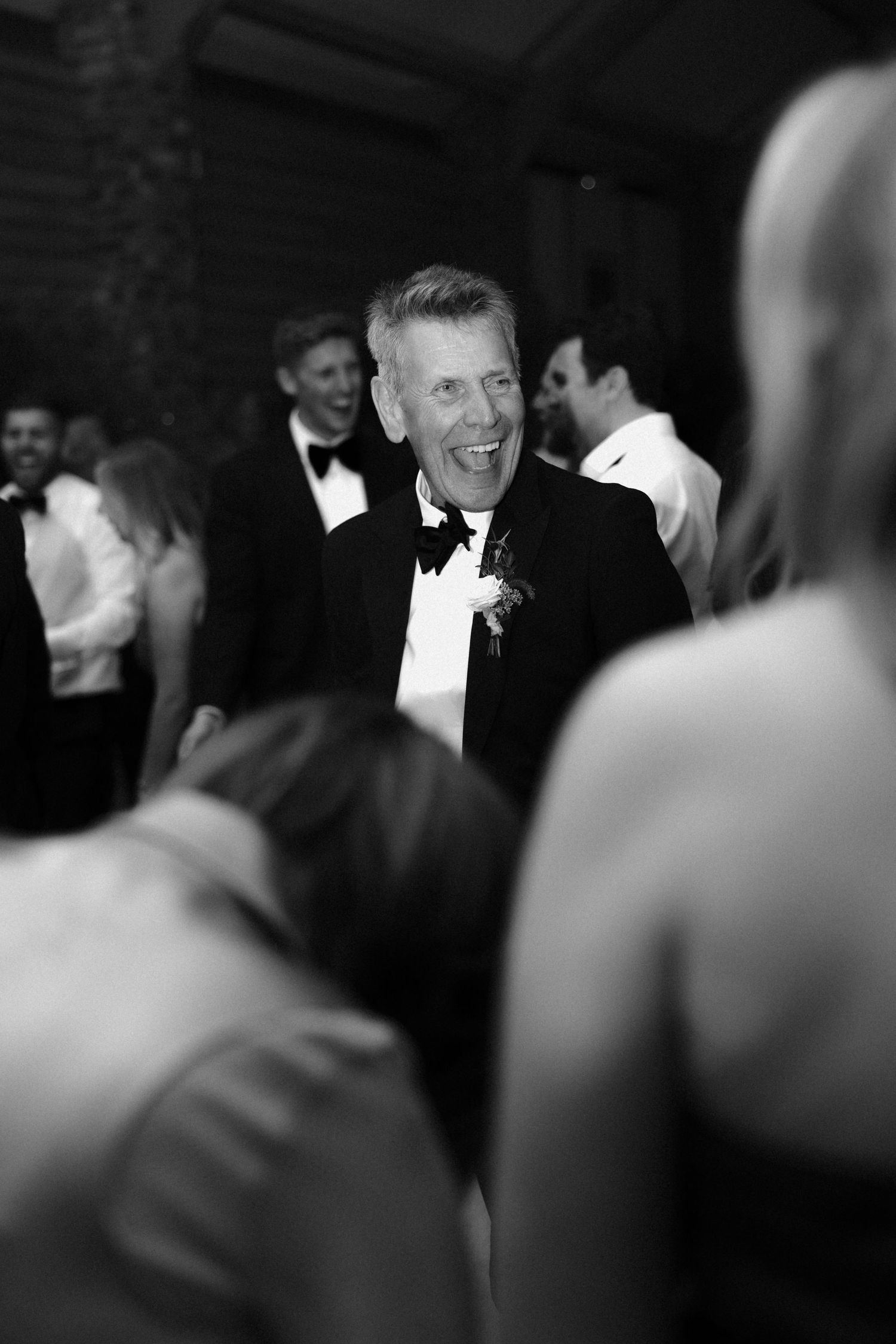 Black and white candid shots of wedding reception guests laughing and celebrating.