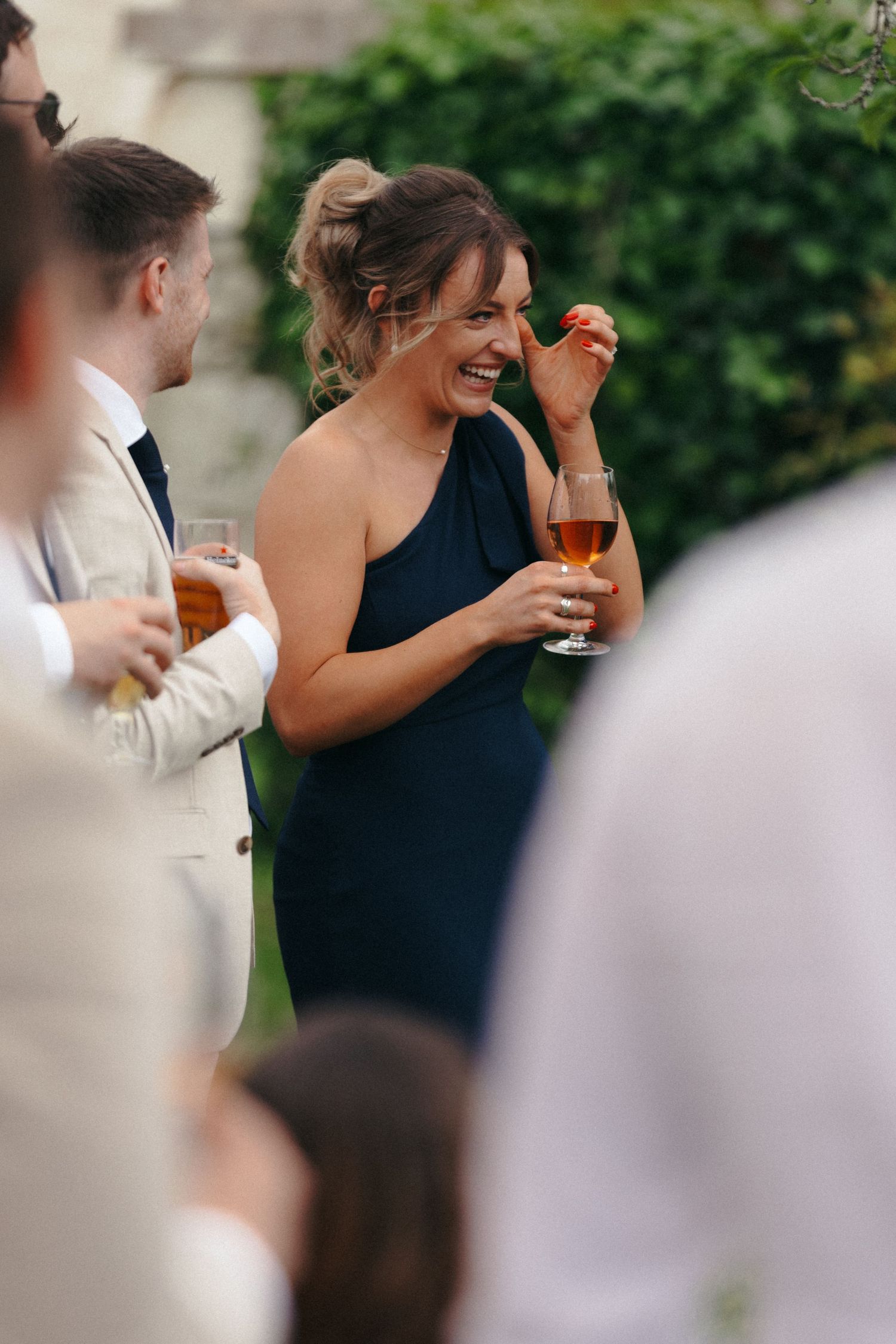 Wedding guests enjoying drinks and conversation at outdoor reception.