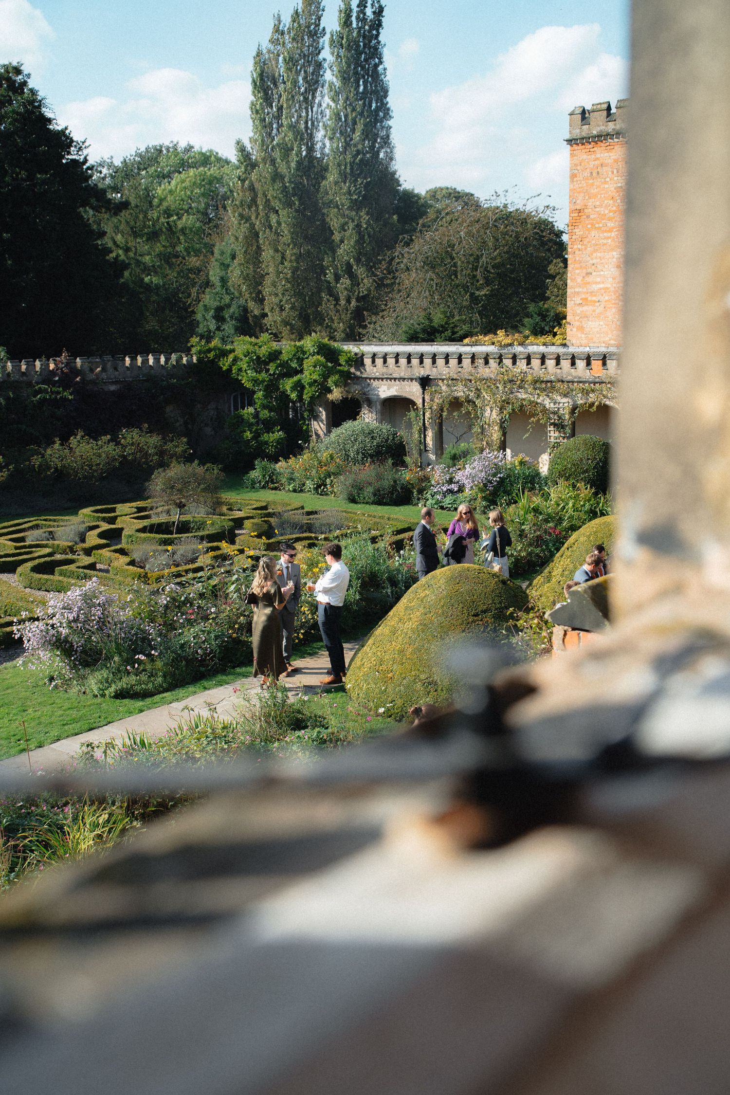 Beautiful garden landscape with manicured hedges and tall trees at a historic estate.