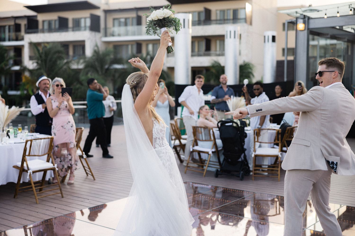 Wedding party dancing and celebrating at an outdoor resort venue.