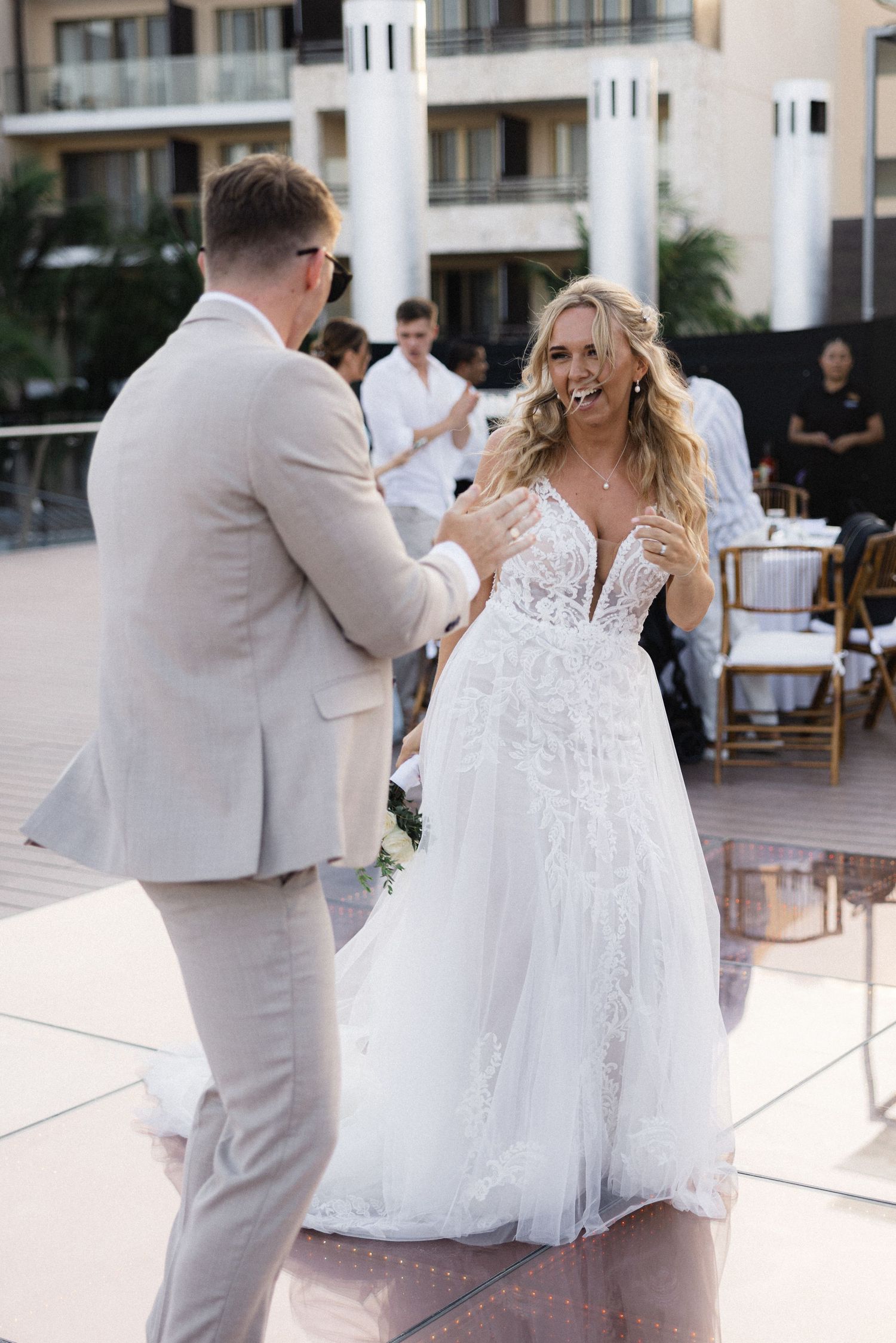 Wedding dance sequence showing flowing white dress and light gray suit.