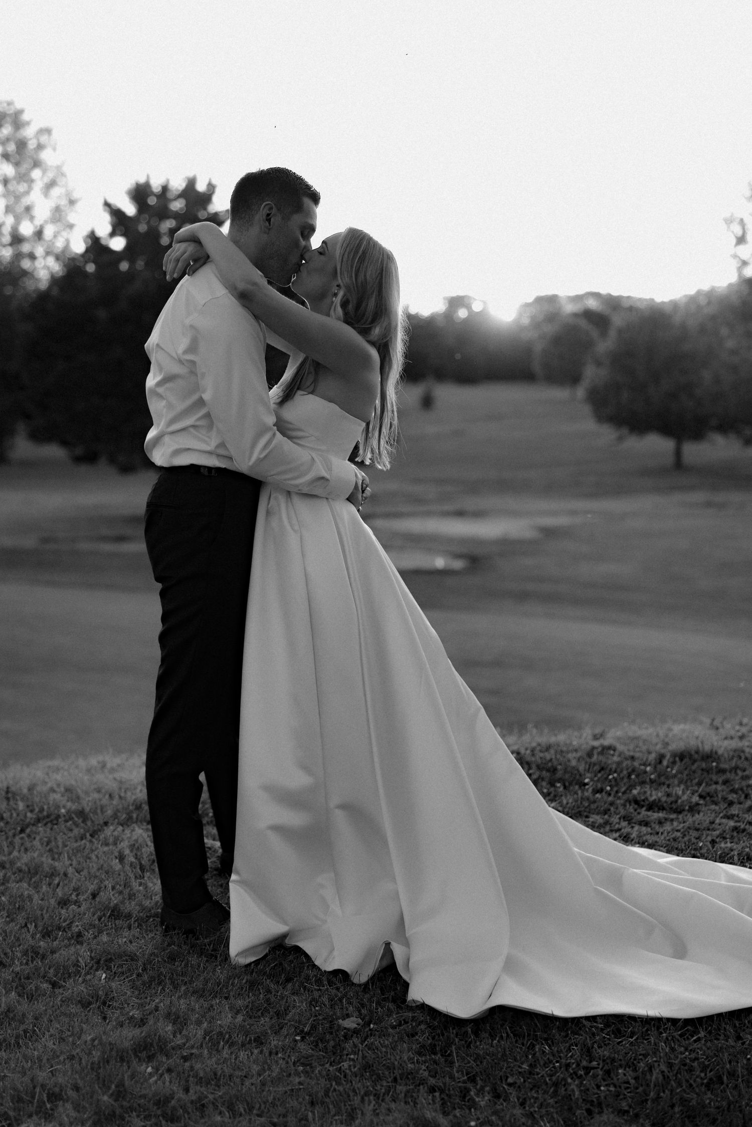 Black and white wedding portraits showing romantic embraces in a scenic outdoor setting.
