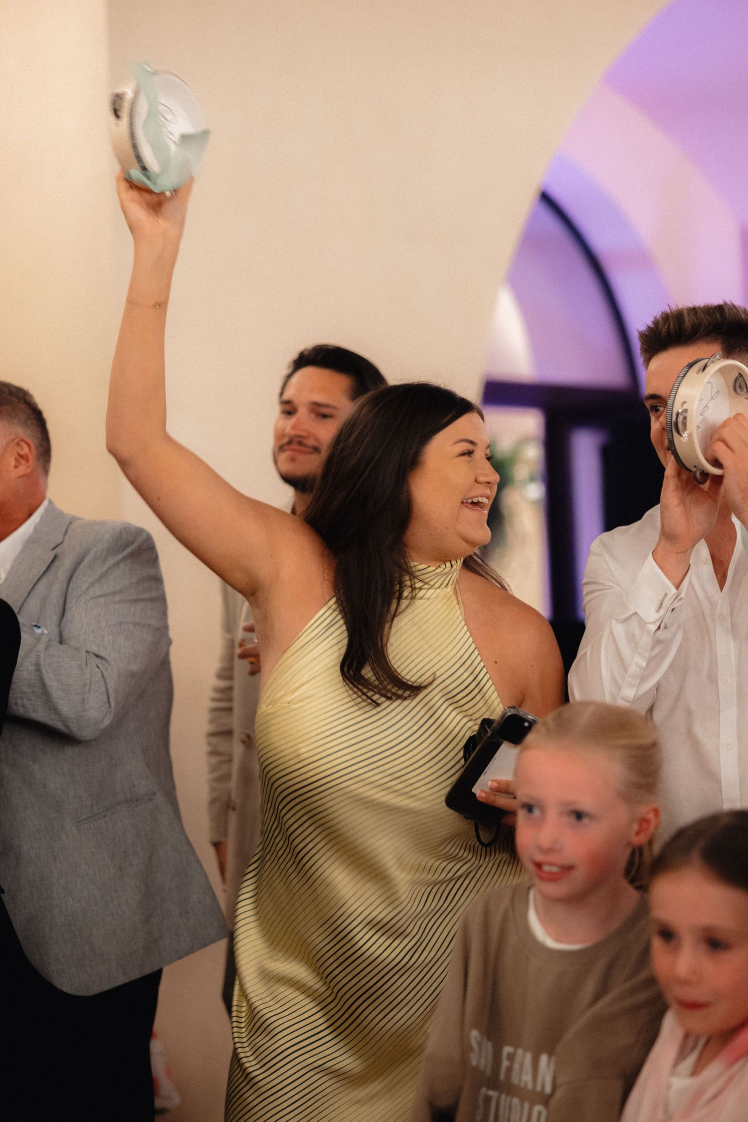 Celebration scene with people dancing and raising their hands in a festive atmosphere.