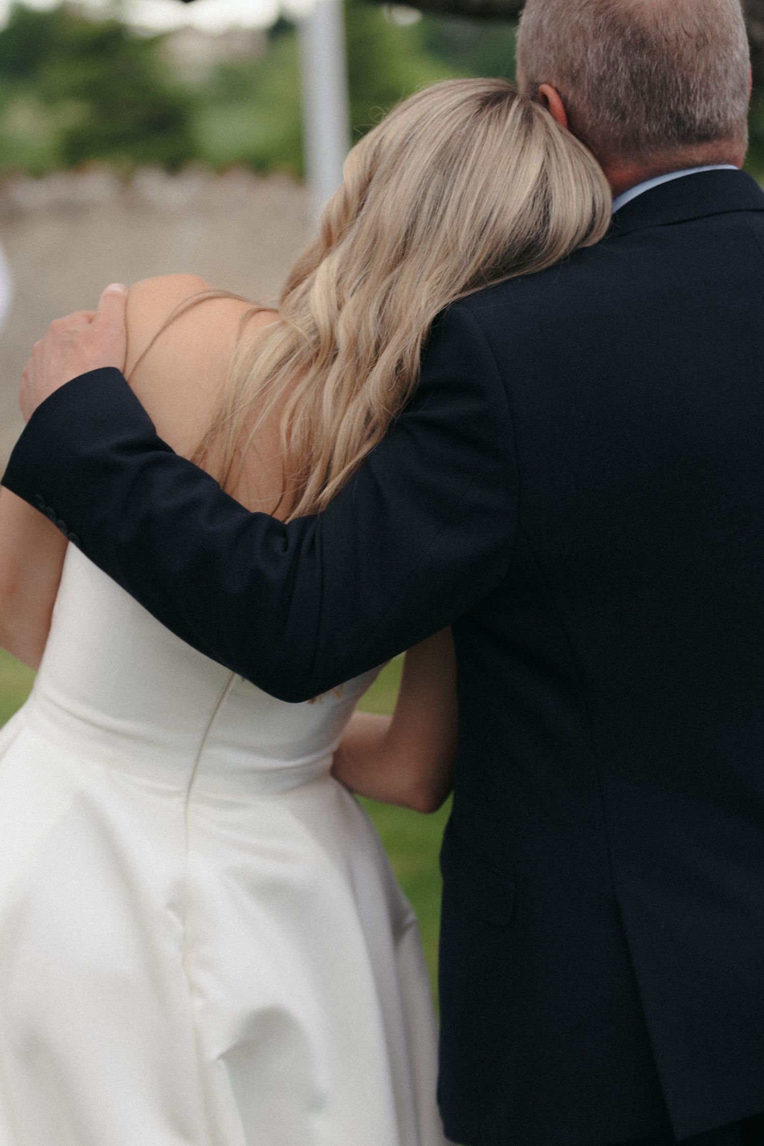Close-up of formal attire and embrace during wedding celebration.