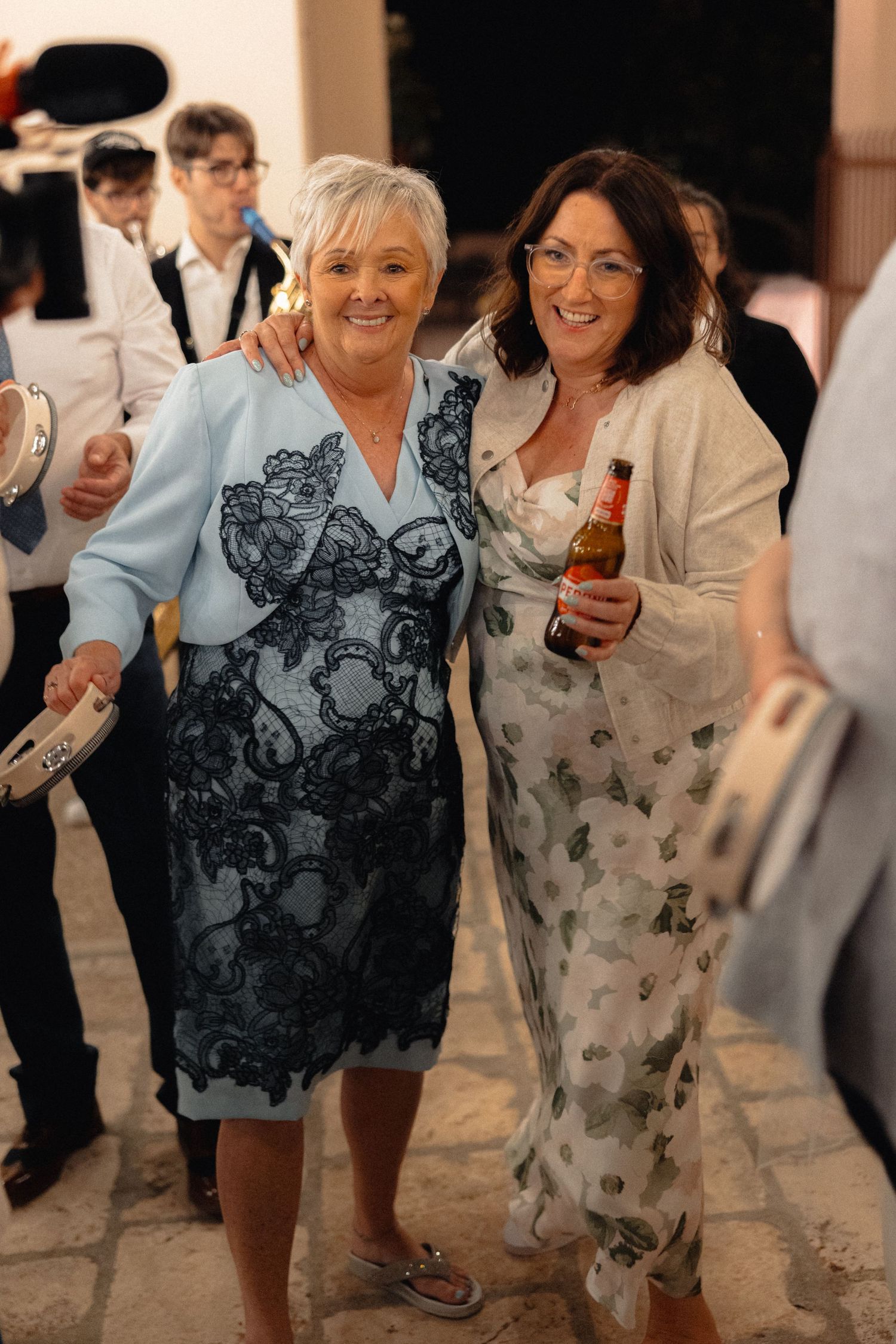 Wedding guests dancing and enjoying drinks at casual reception party.