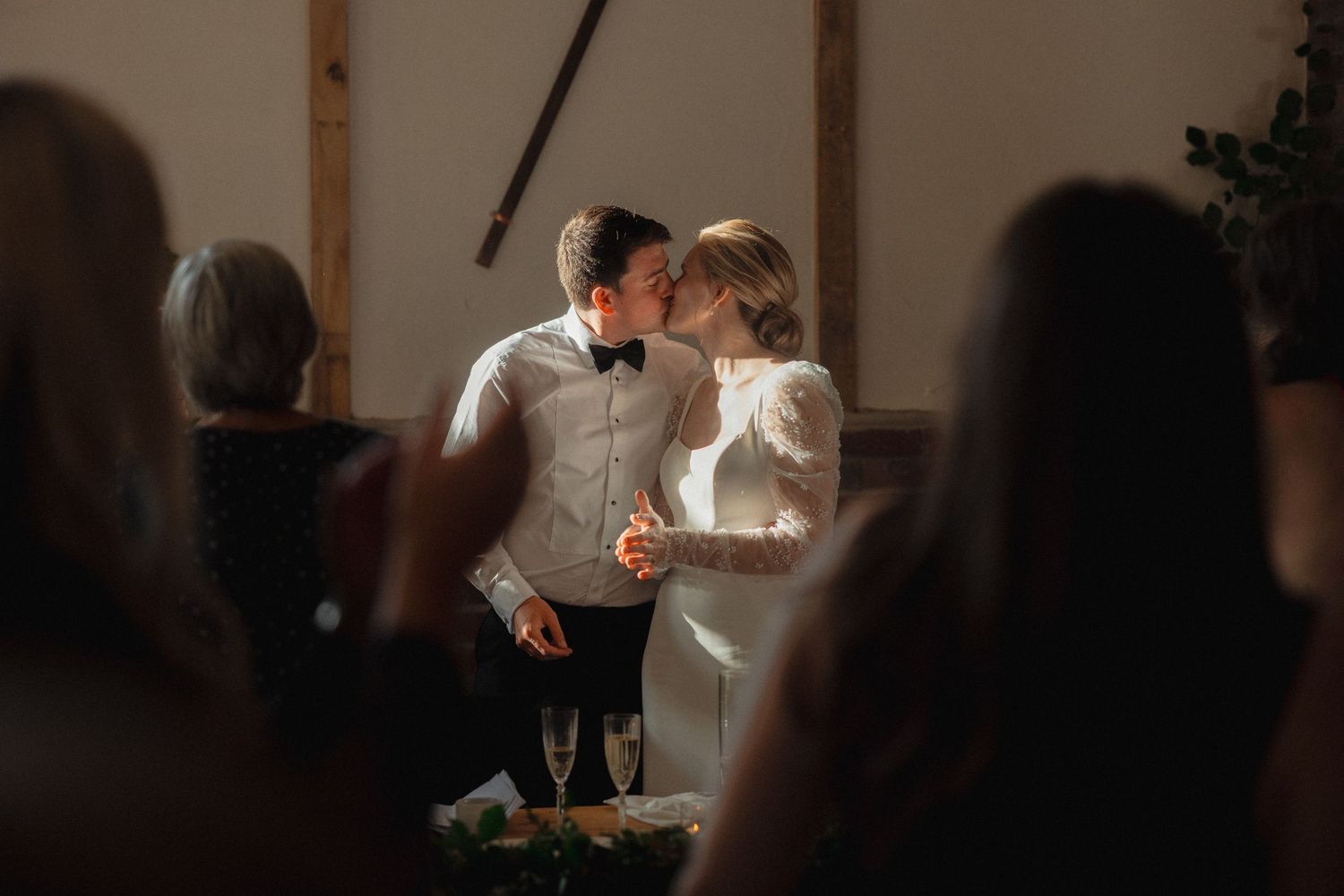 Candlelit wedding reception scene with guests dining at tables.