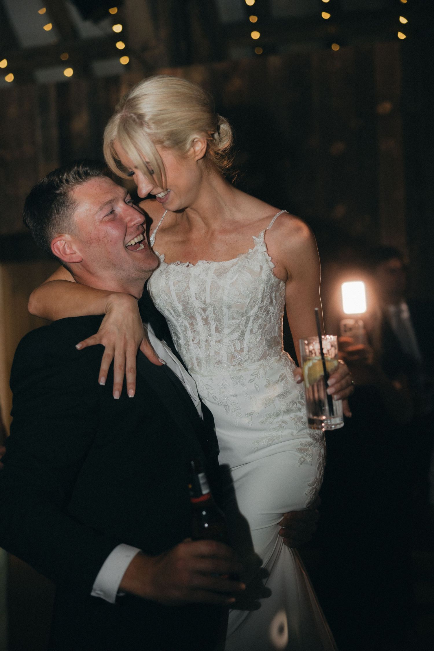A candid moment of laughter between newlyweds during their wedding reception.