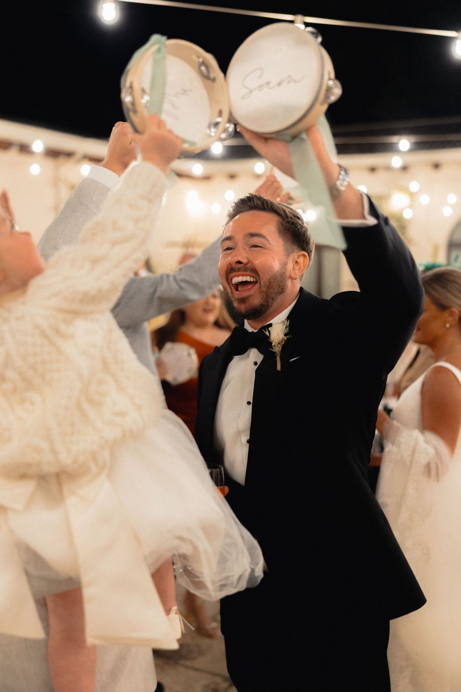 Wedding party dancing and celebrating with high energy during an evening reception.