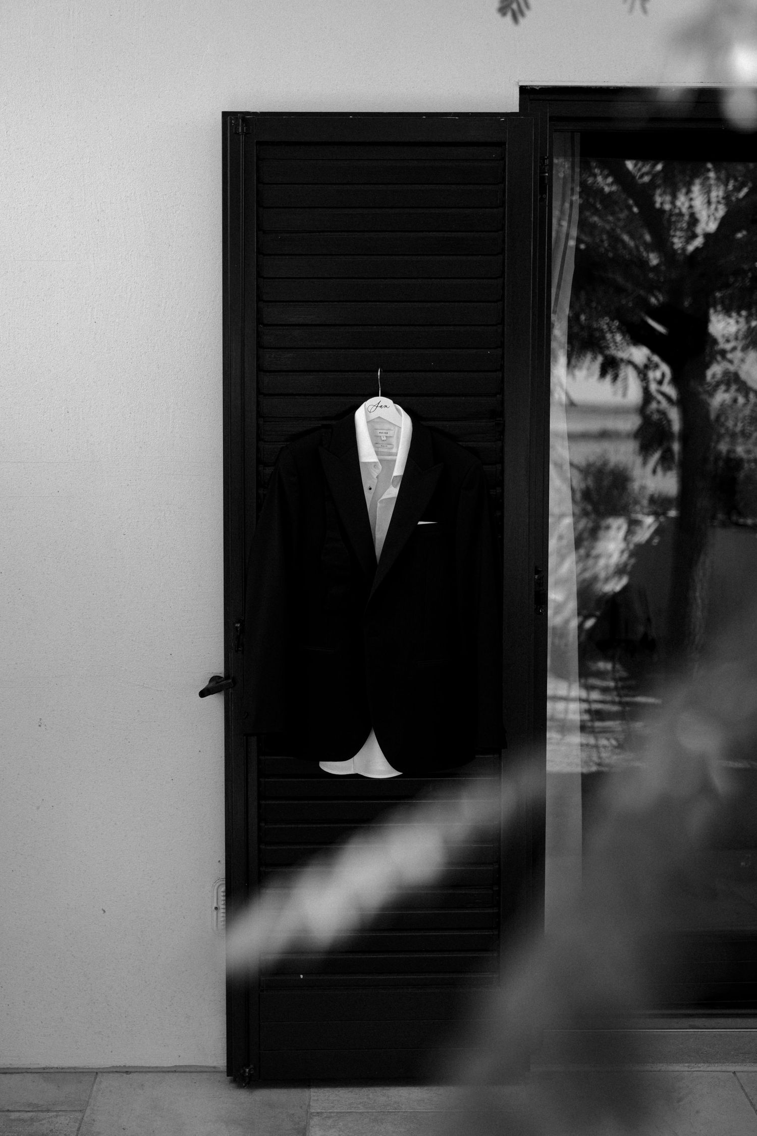 Black and white architectural detail of windows and shutters creating dramatic shadows.