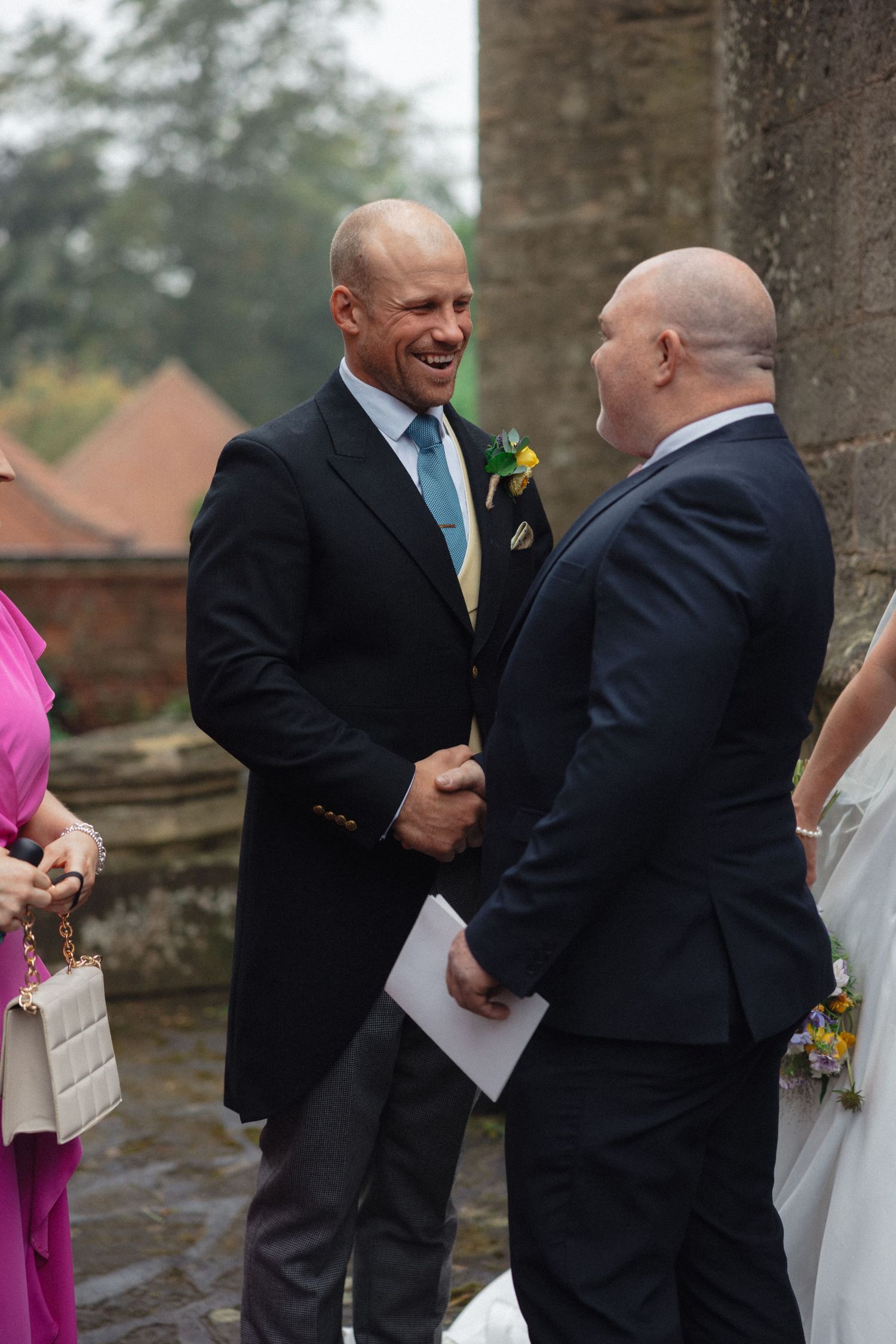 Two guests sharing a lighthearted moment outside historic church building.