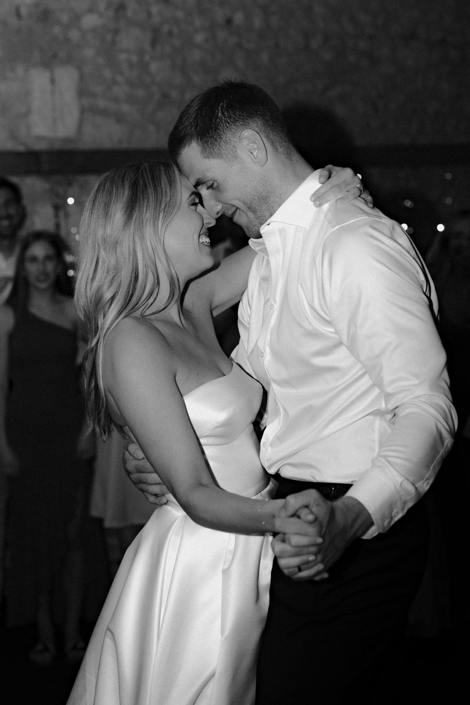 Intimate black and white photo of couple dancing at their wedding reception.