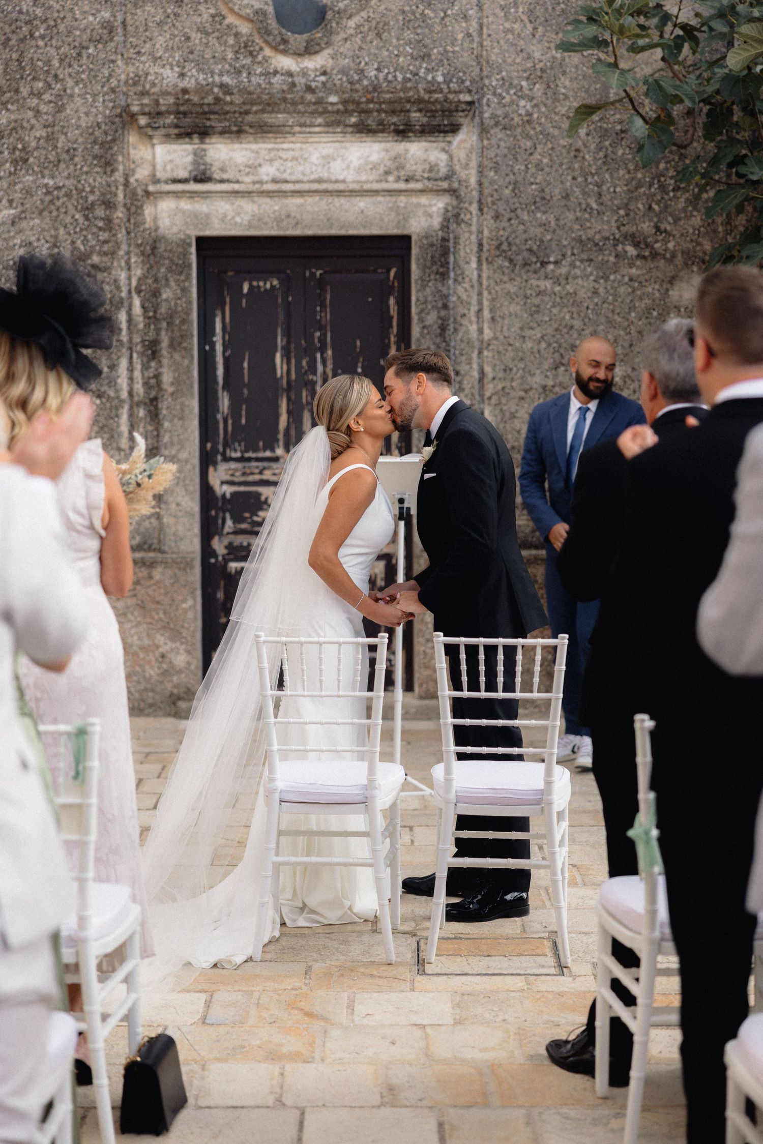 Candid wedding moments captured in sequence against a rustic stone wall setting.