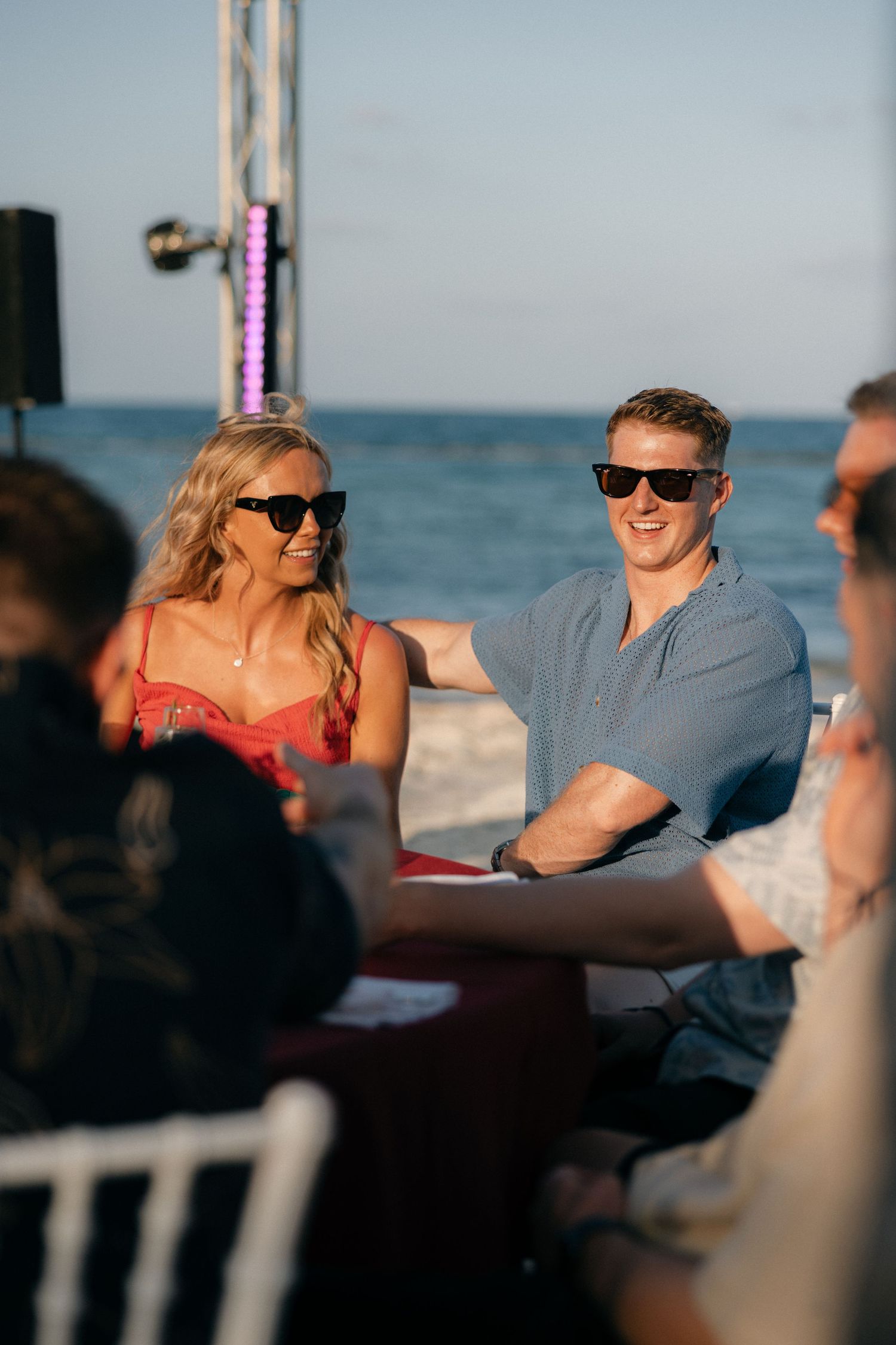 Guests enjoying outdoor beachside gathering with ocean view.